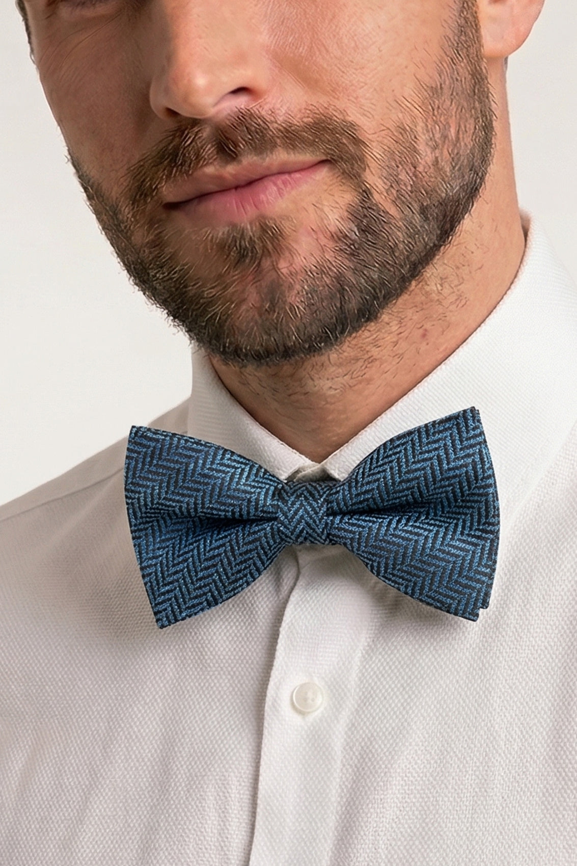 Oswin Hyde Herringbone Blue Bowtie, featuring a classic herringbone pattern. deep blue hue and textured fabric