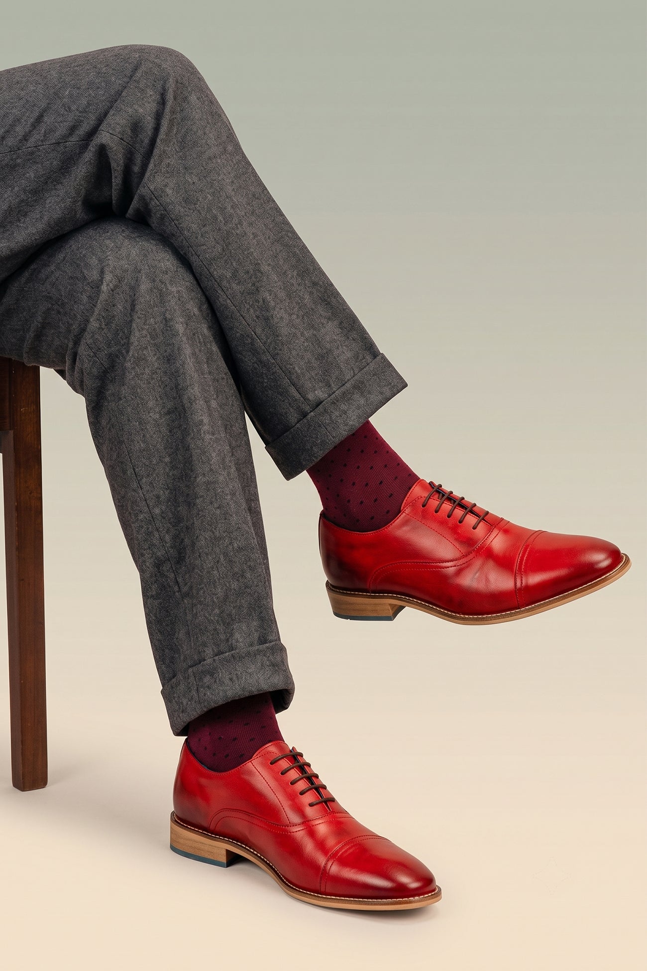 Model wearing William cherry red leather oxford shoes for men by Oswin Hyde – elegant toecap lace-up design with polished leather and timeless sophistication.