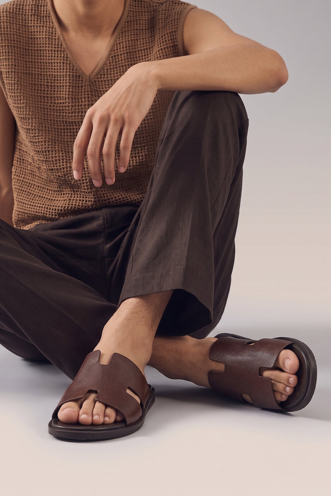 Model wearing Men’s Phoenix Brown sandals in high-quality brown leather featuring a minimalist hyde strap H-frame design.
