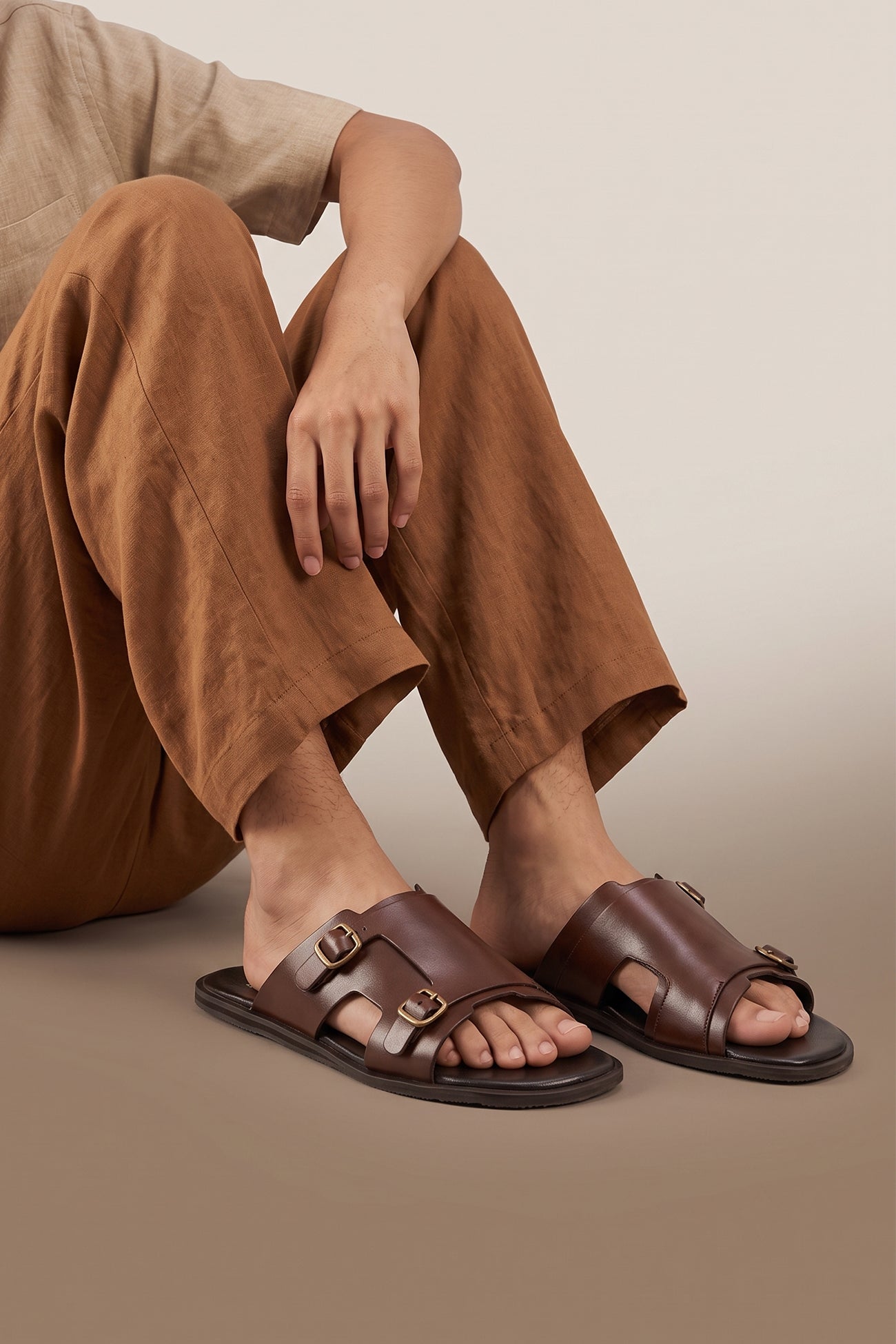 Model wearing Logan brown men’s leather sandals with premium stitching and timeless design, ideal for warm-weather comfort and smart-casual summer looks.