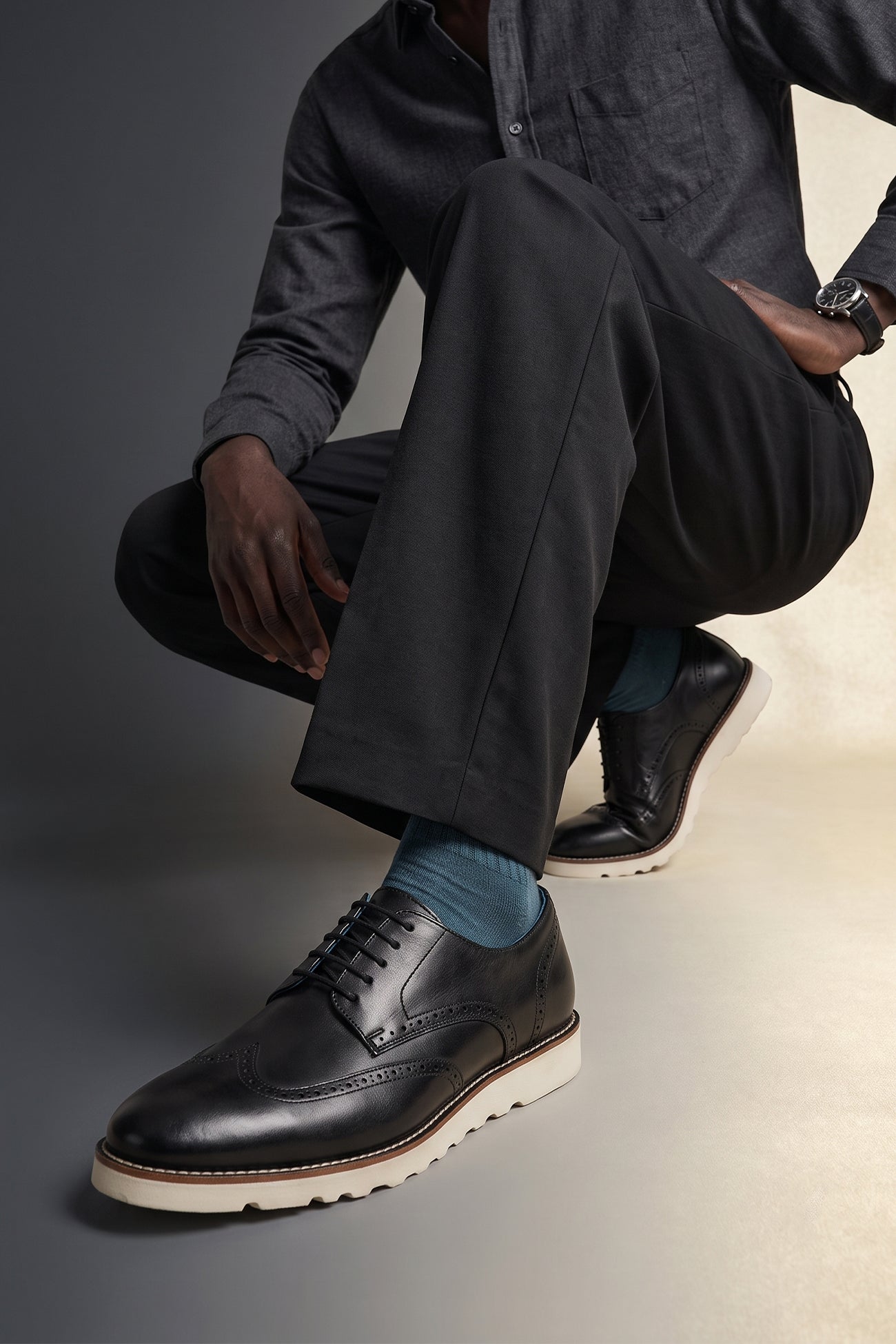 Model wearing Conner Black derby trainers for men made from premium leather, featuring stylish design ideal for casual and formal wear.