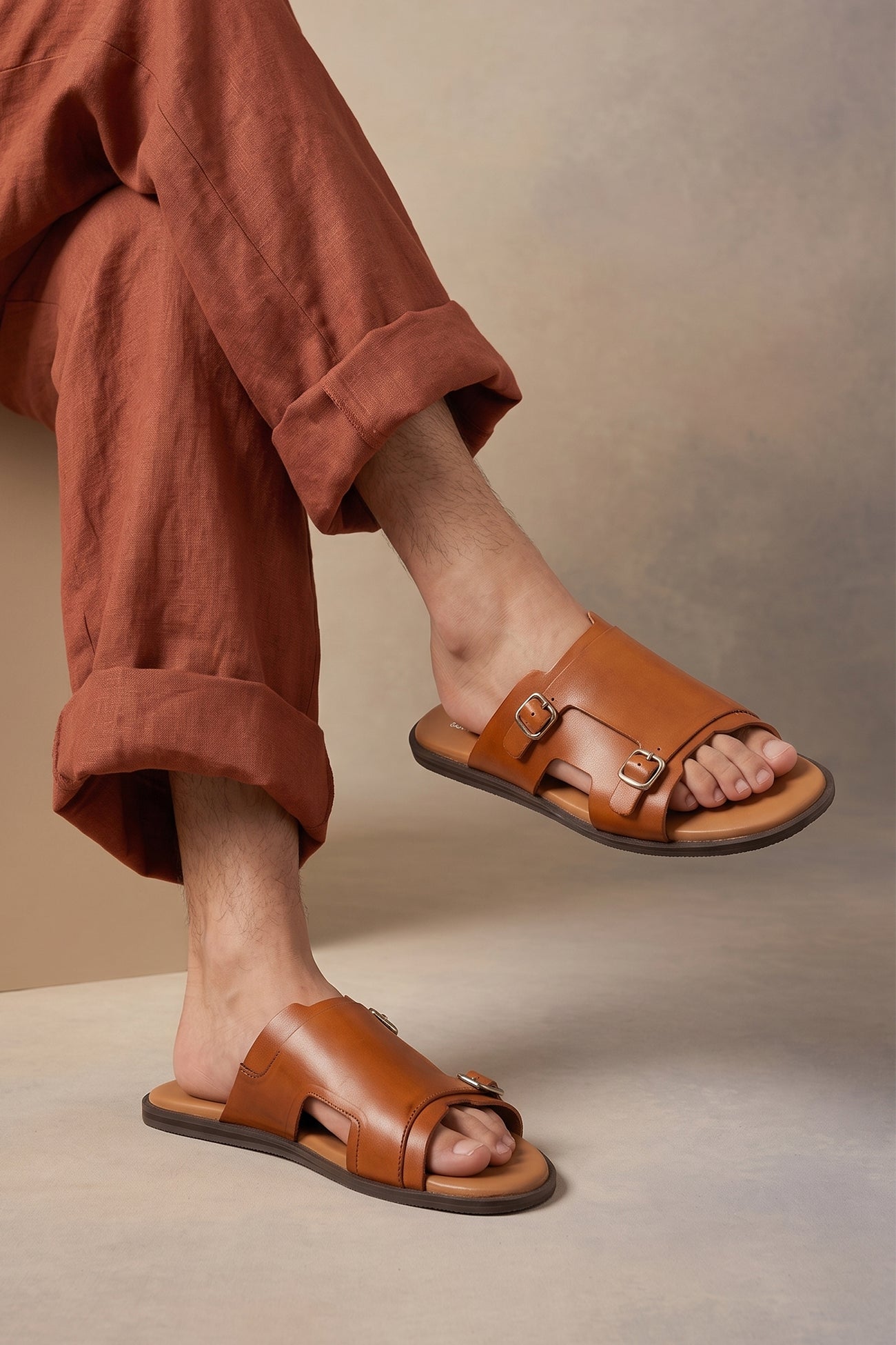 Model wearing Logan tan leather sandals for men made from premium leather with open-toe design and stitched sole, ideal for summer comfort and smart-casual wear.