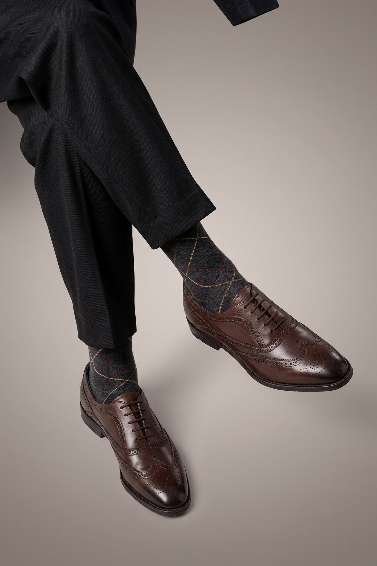 Model wearing Stokes Brown Oxford Brogue Wing Cap leather shoes for men, crafted with premium brown leather and intricate brogue detailing for formal style.