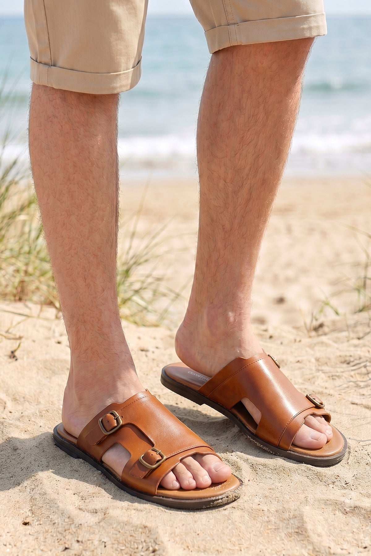 Model wearing Logan tan leather sandals for men made from premium leather with open-toe design and stitched sole, ideal for summer comfort and smart-casual wear.