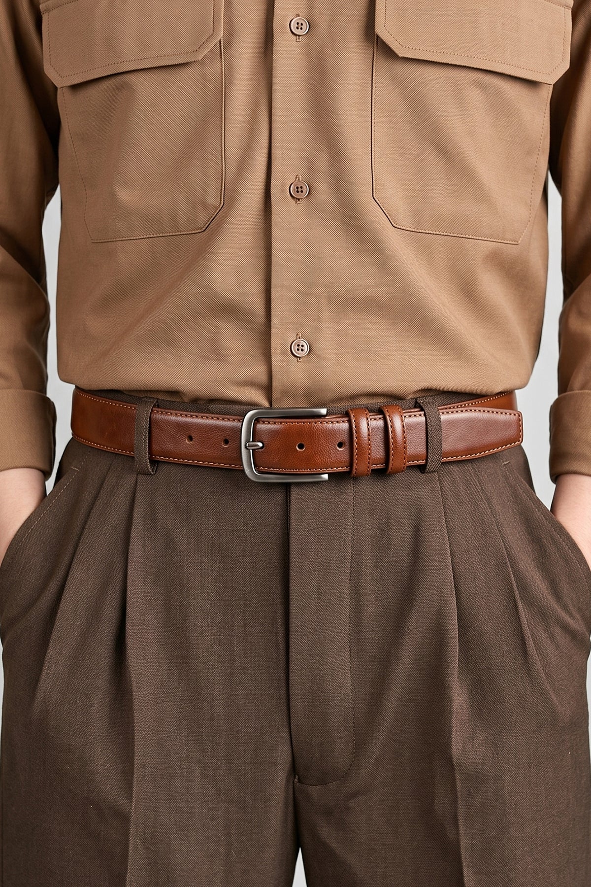 Man wearing Oswin Hyde Neil Tan men's leather belt in rich tan brown - Full-grain leather with polished brass buckle, designed for formal weddings, business attire and smart casual ensembles