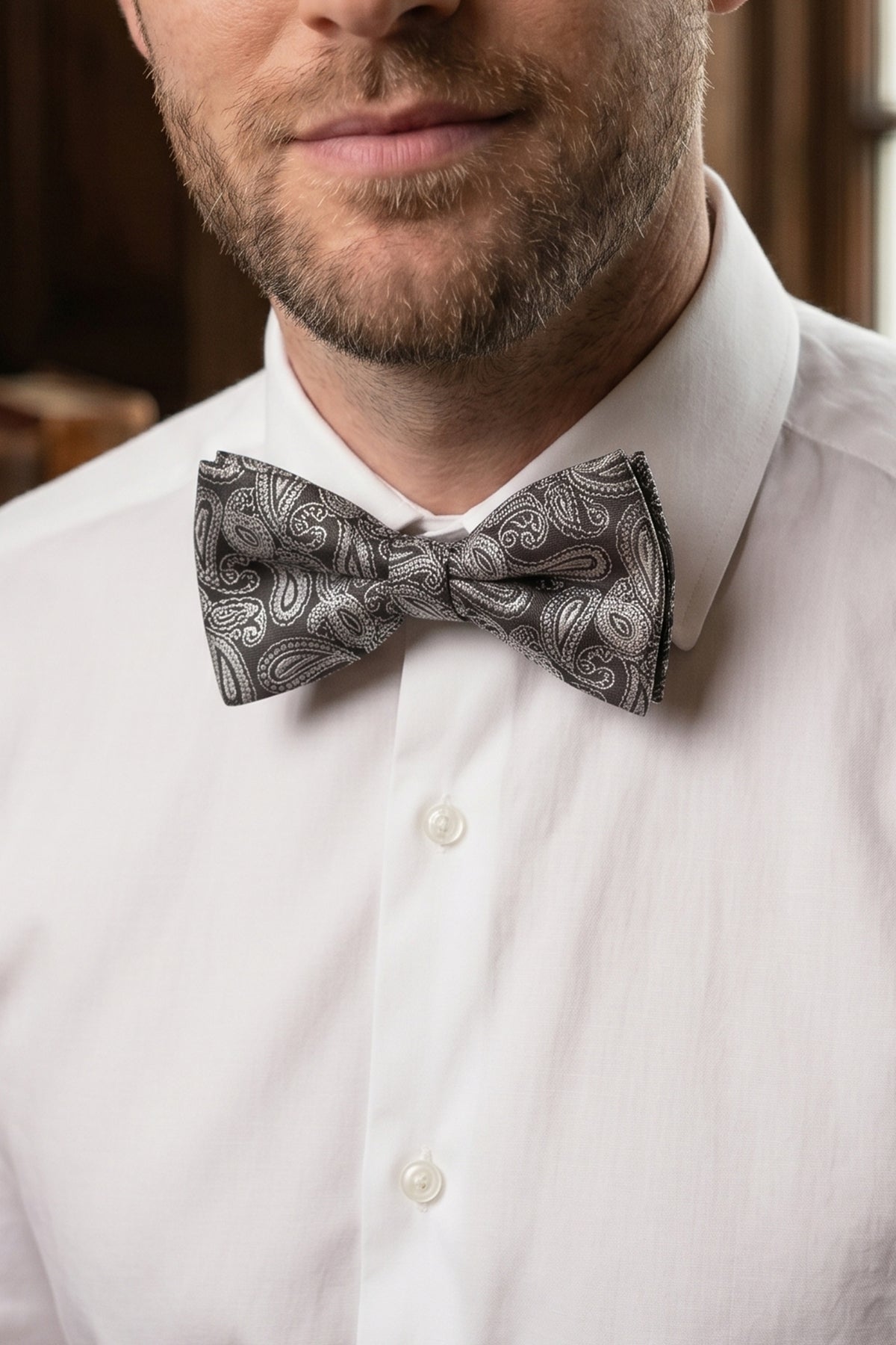 Man wearing Paisley Pattern Black Bowtie, featuring an elegant paisley design and has rich black hue and detailed pattern
