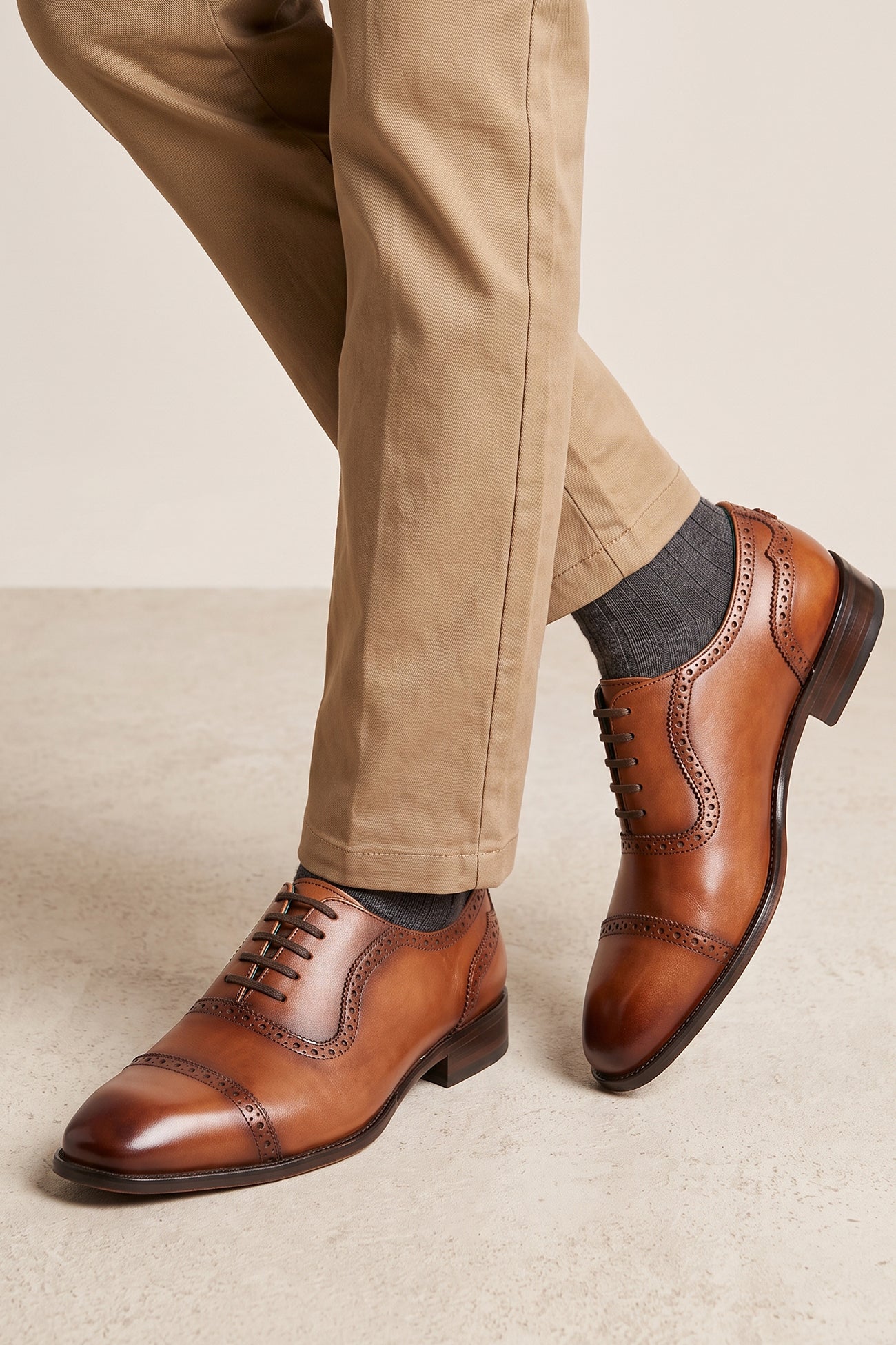 The men's smart tan oxford shoes showcase a classic cap-toe design and premium full-grain leather, perfect for summer weddings and sharp business attire.