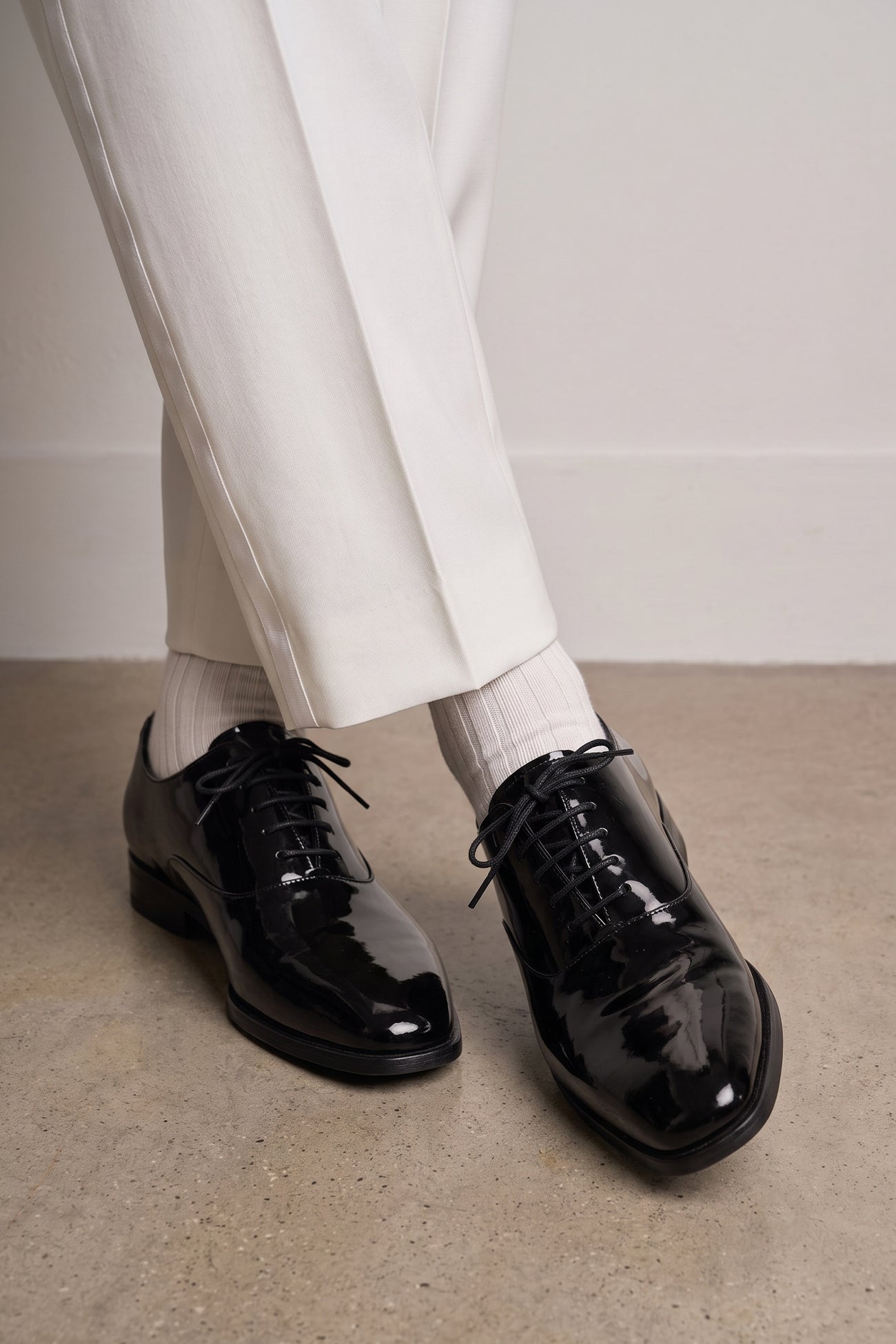 Model wearing Bow Black men's leather patent shoes. The men's smart black shoes exude luxury and sophistication, perfect for weddings