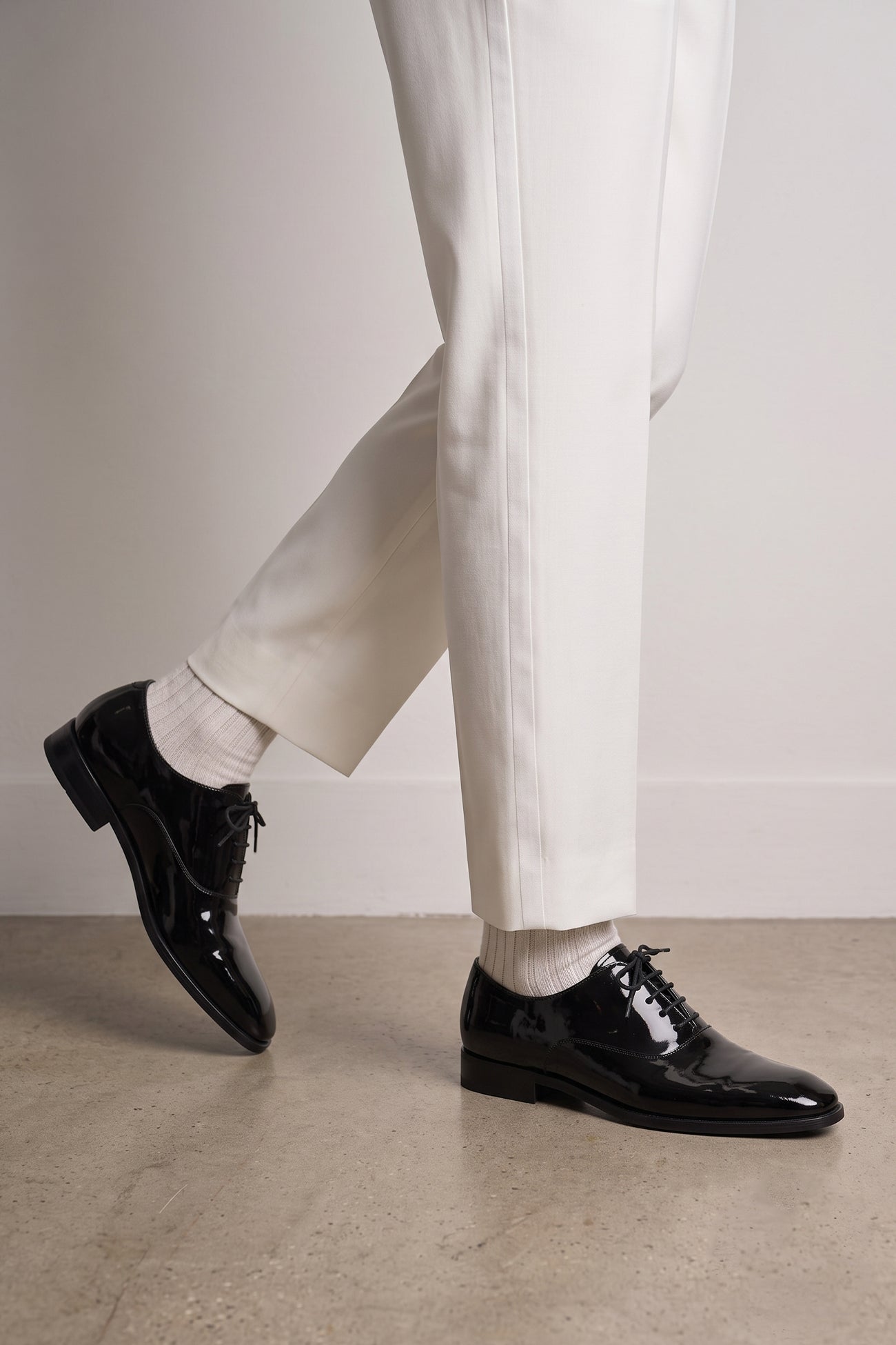 Model wearing Bow Black men's leather patent shoes. The men's smart black shoes exude luxury and sophistication, perfect for weddings