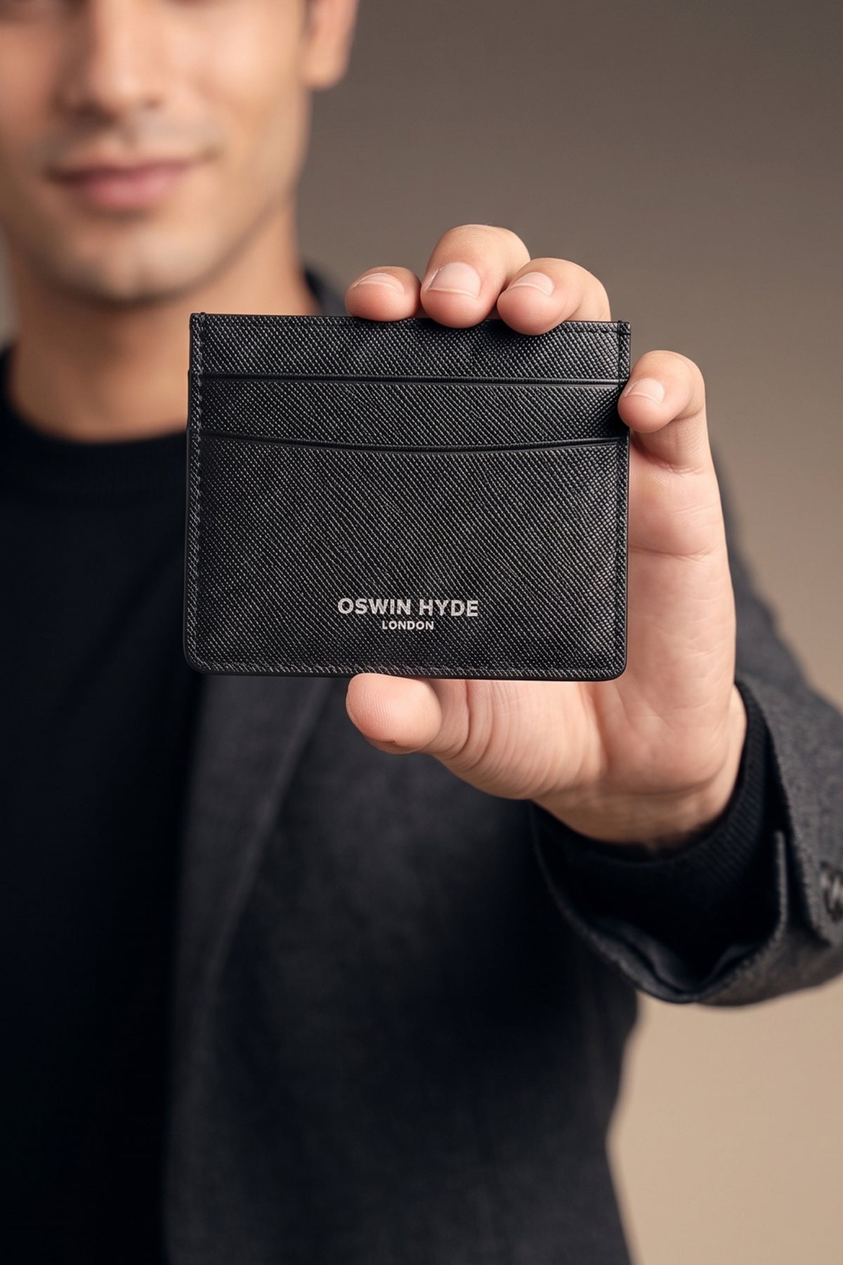 Man holding Holborn black saffiano leather card holder for men by Oswin Hyde – slim luxury wallet with silver embossed branding and textured premium finish.