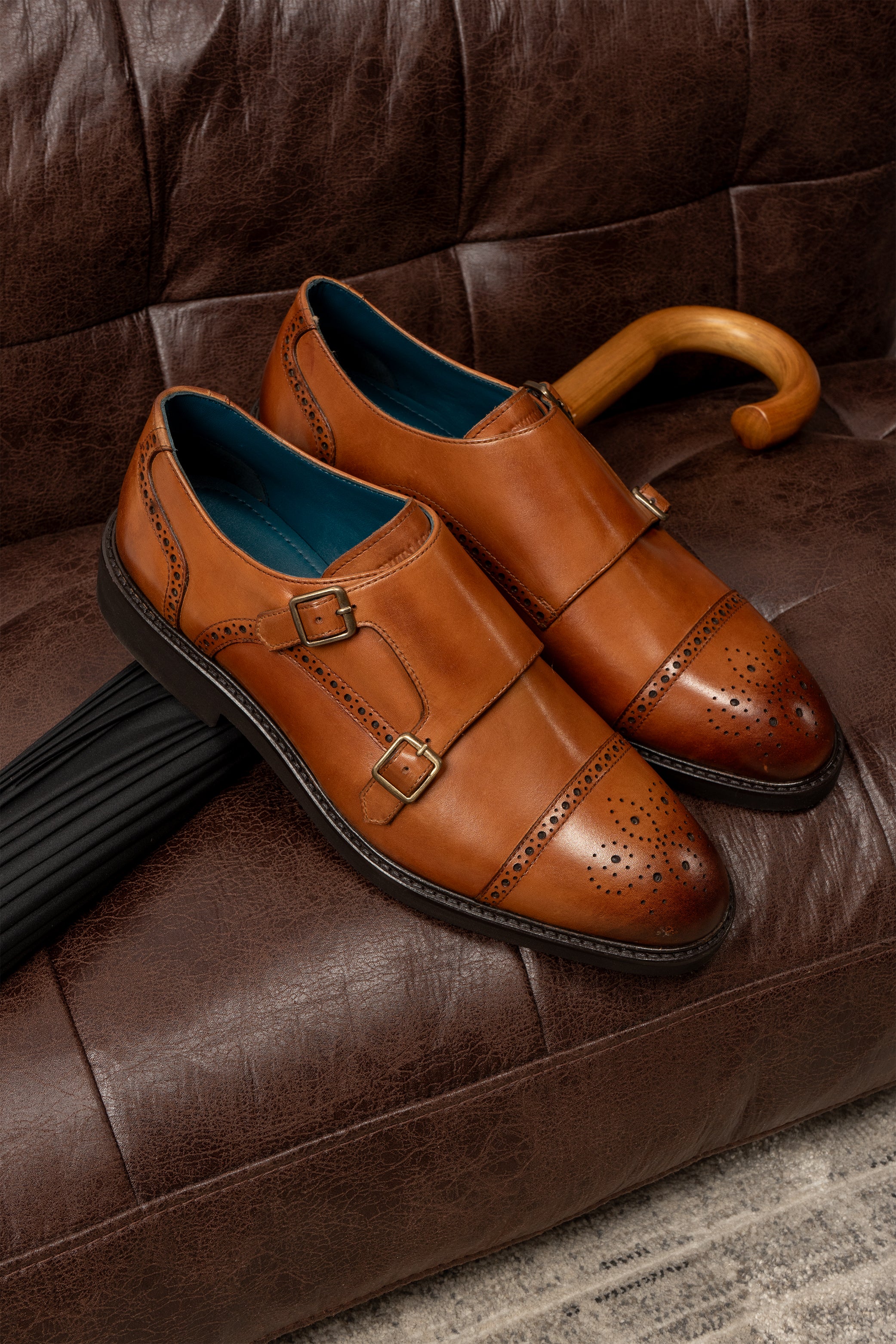 Men’s Shelby tan leather monk strap brogue shoes featuring intricate broguing and premium craftsmanship for formal and smart-casual occasions.