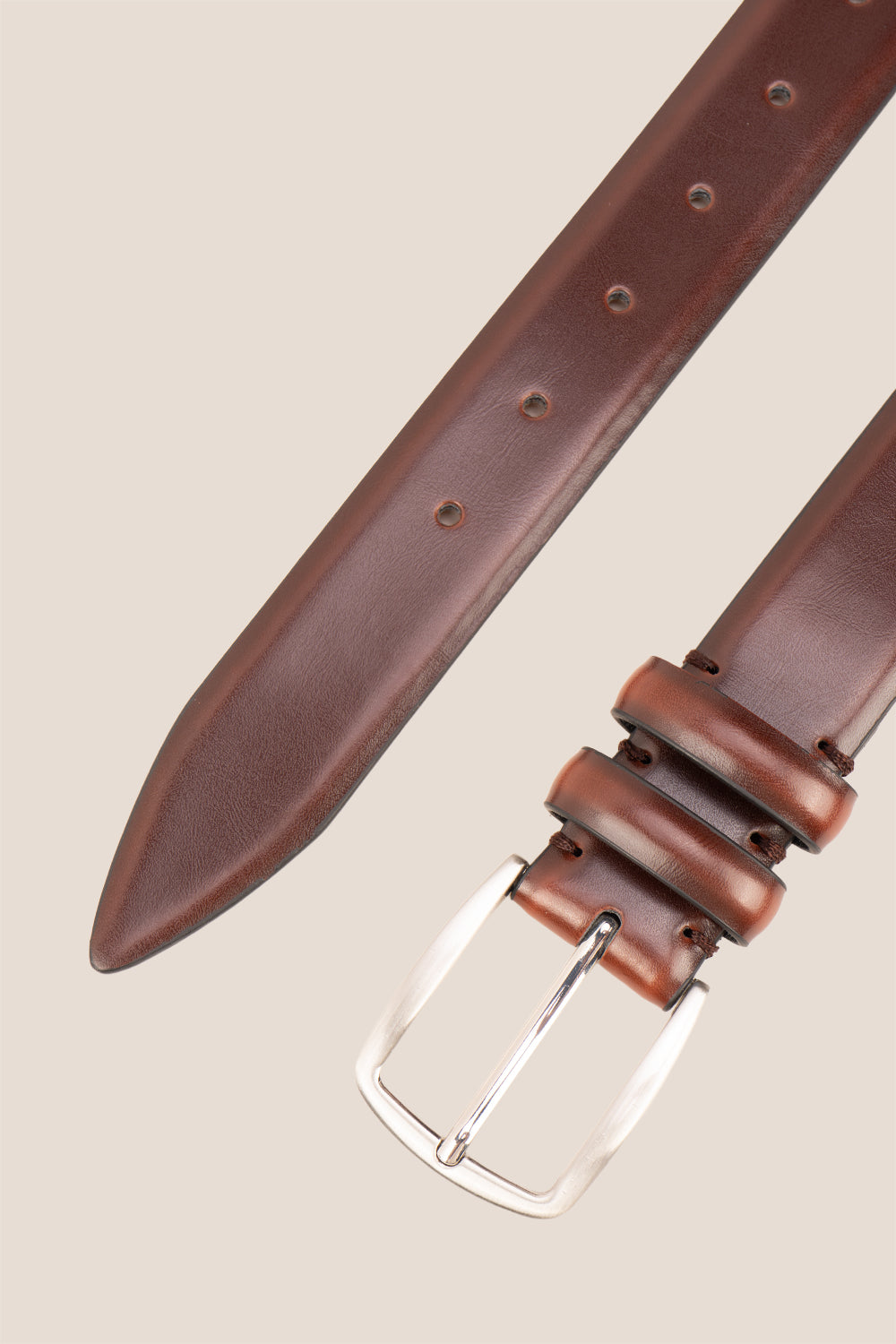 Gavin Brown leather belt with a silver buckle on a beige background