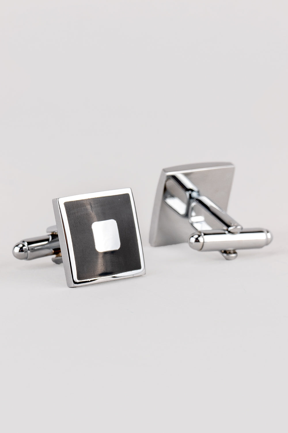 Square black men’s cufflinks featuring deep black enamel set in polished metal with intricate detailing for precise, formal elegance.
