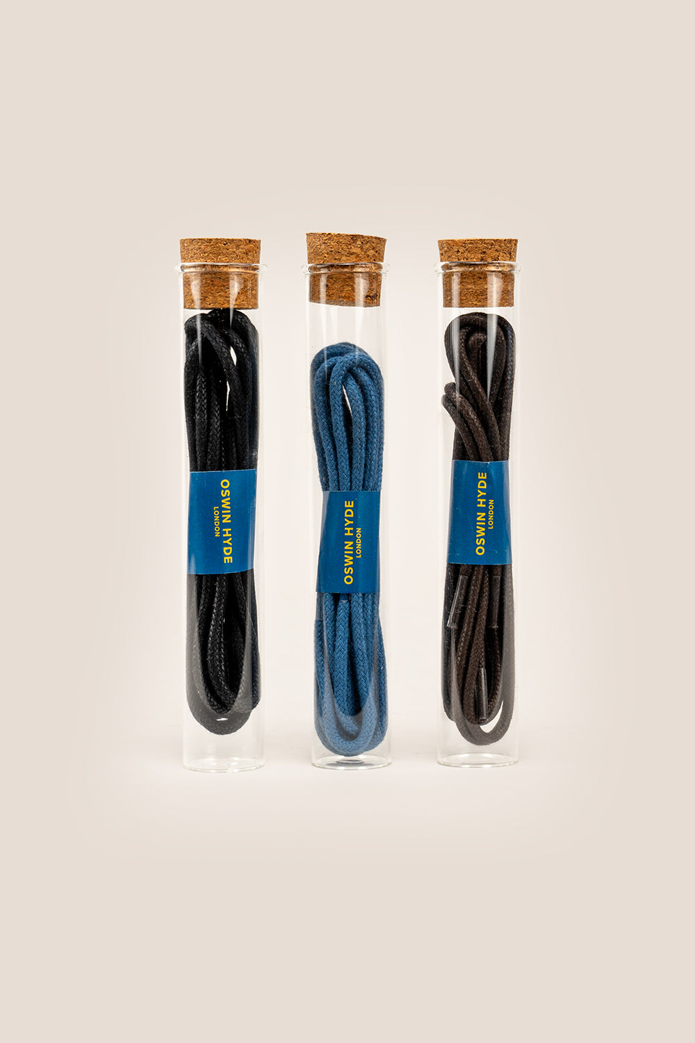 Black 4mm round waxed cotton boot laces, 120mm length, beeswax-polished, elegantly packaged in Oswin Hyde’s signature glass tube.
