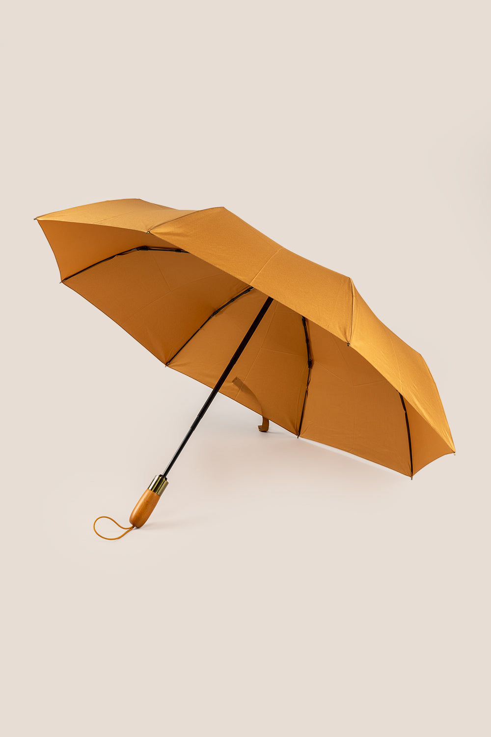Ian Sand windproof folding umbrella with wooden handle, lightweight frame, luxury finish, and matching pouch for stylish travel and everyday protection.