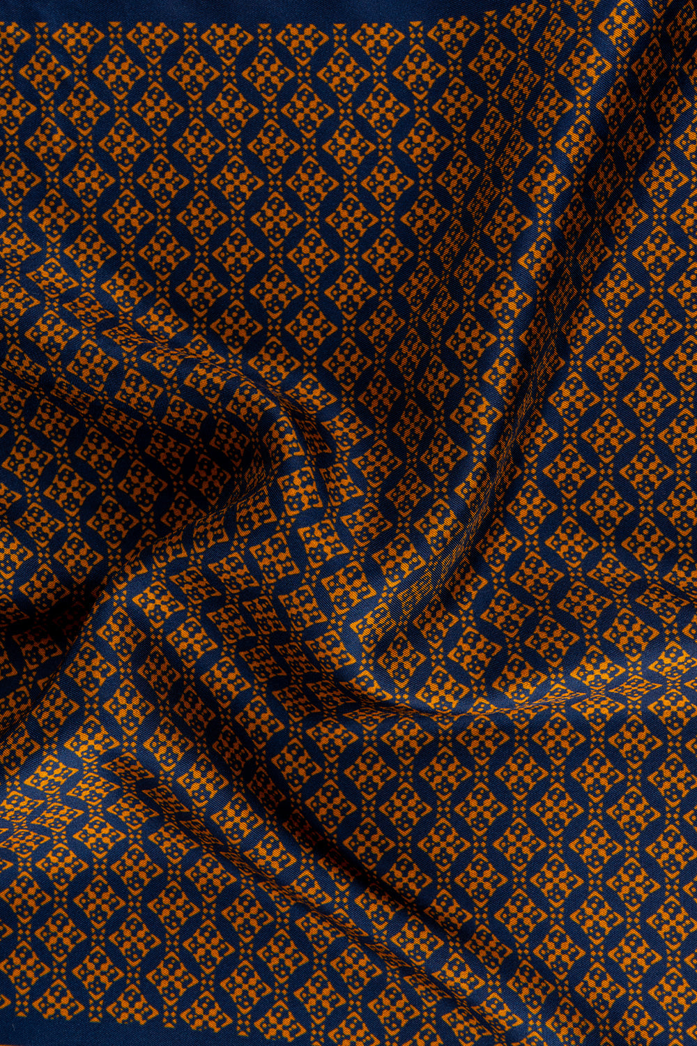 Men’s orange silk handkerchief with an intricate geometric pattern, crafted for weddings, formal occasions, or stylish smart dressing.