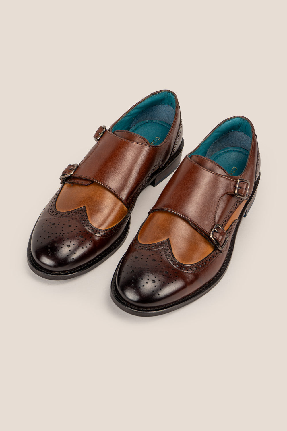 Warren brown monk strap wing cap brogue men’s leather shoes featuring premium leather and detailed wingtip perforations.
