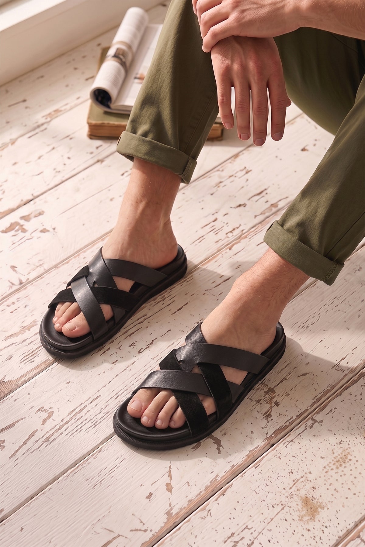 Men’s Rowan Black slide sandals featuring a minimalist black leather X-strap design and a sleek matte finish.