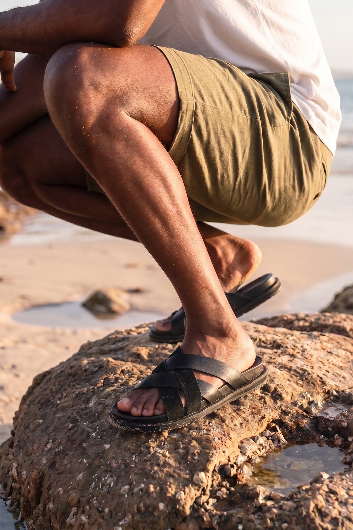Men’s Rowan Black slide sandals featuring a minimalist black leather X-strap design and a sleek matte finish.
