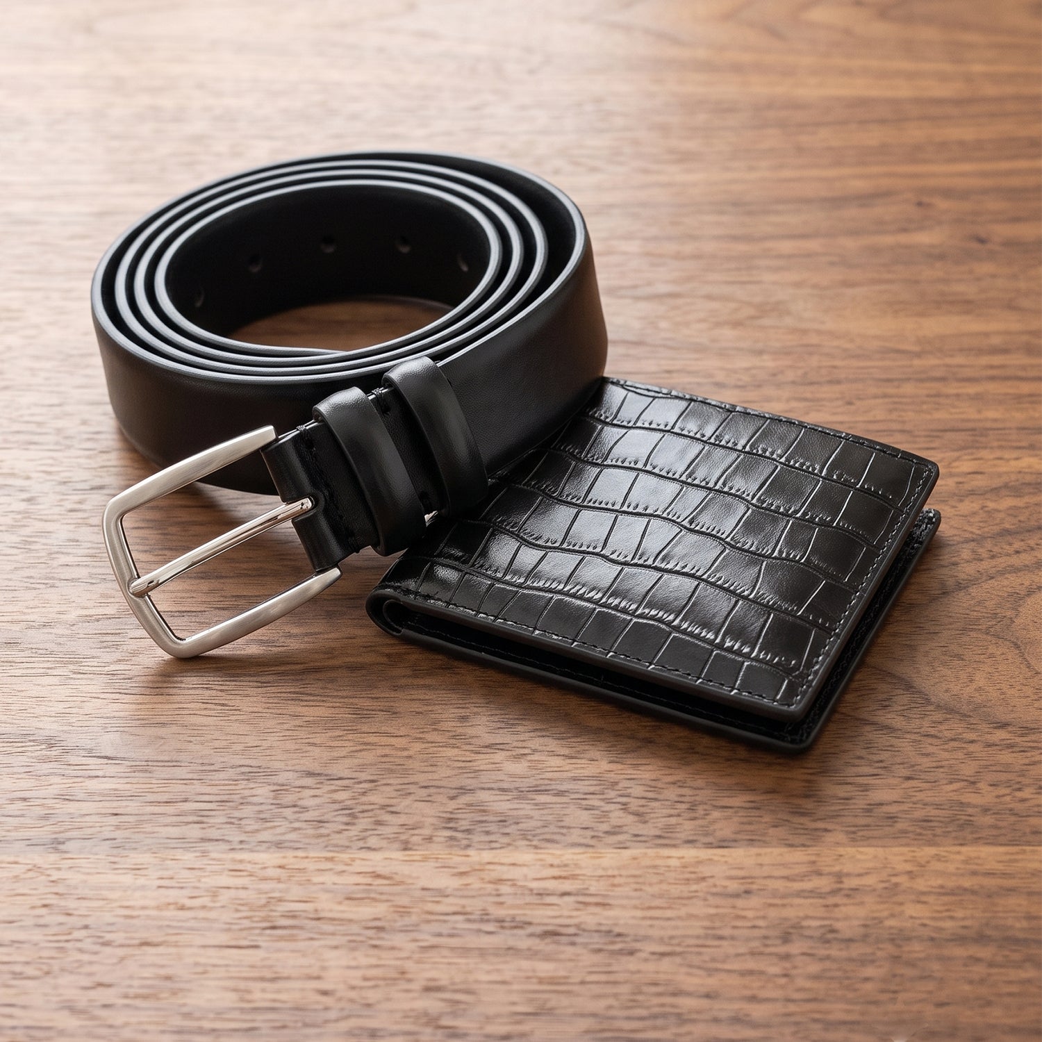 Premium men's leather accessories set featuring a rolled black dress belt with a brushed silver buckle and a matching black croc-effect embossed leather wallet