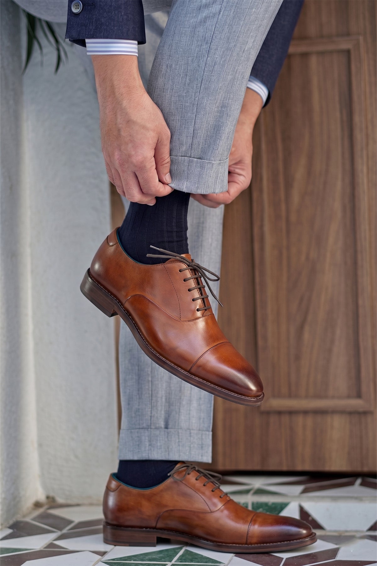 Model wearing Men’s Jarred Tan dress shoes in high-quality tan leather featuring a classic Oxford silhouette and toecap detail.