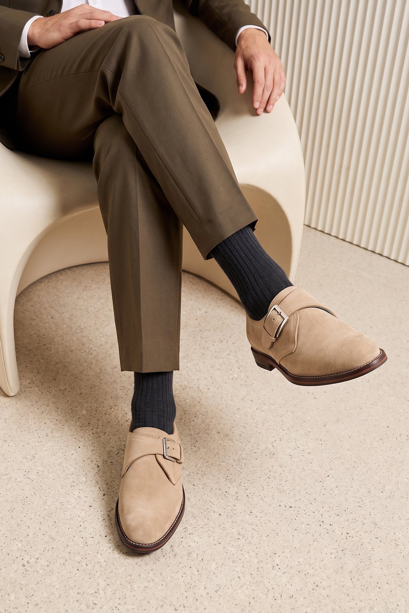 Man wearing Premium men's sand suede single monk strap shoes by Oswin Hyde London, featuring a plain toe, adjustable silver buckle, contrast sole stitching, and a cushioned teal interior.