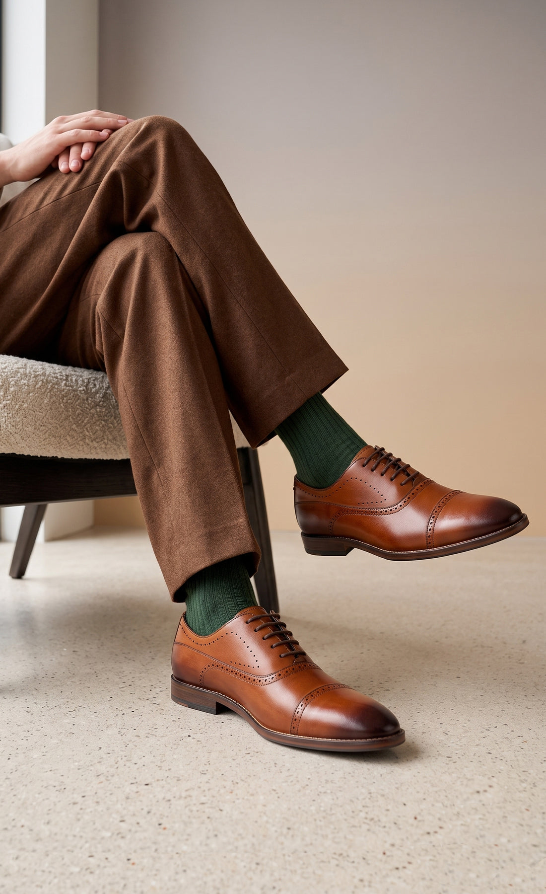Man wearing Premium men's tan leather oxford shoes by Oswin Hyde London, featuring a cap toe with decorative perforations, closed lacing, contrast welt stitching, and a cushioned teal interior.