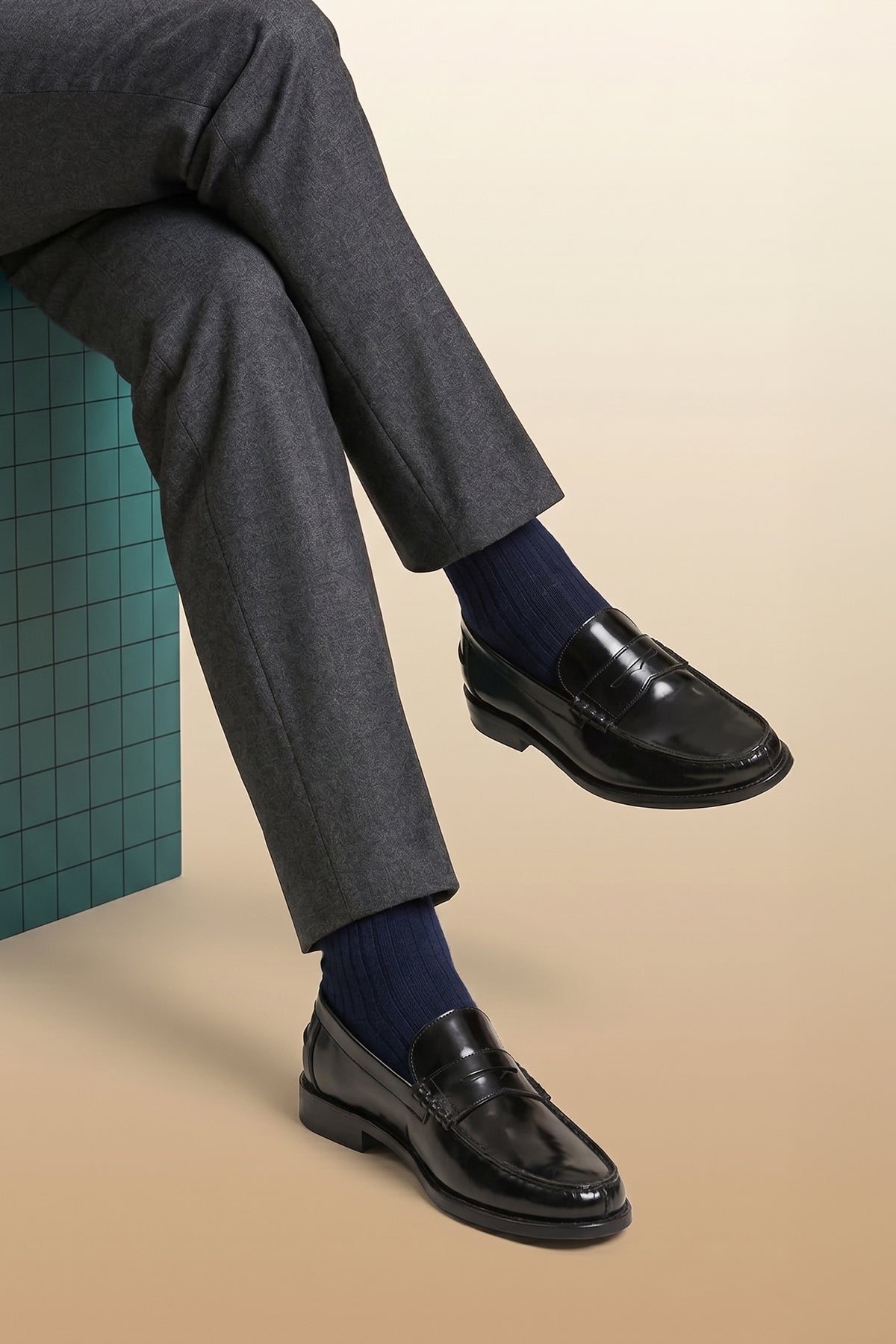 Model wearing Oswin Hyde Peter Black leather penny loafers for men, crafted to deliver a classic and refined style. Constructed from premium leather