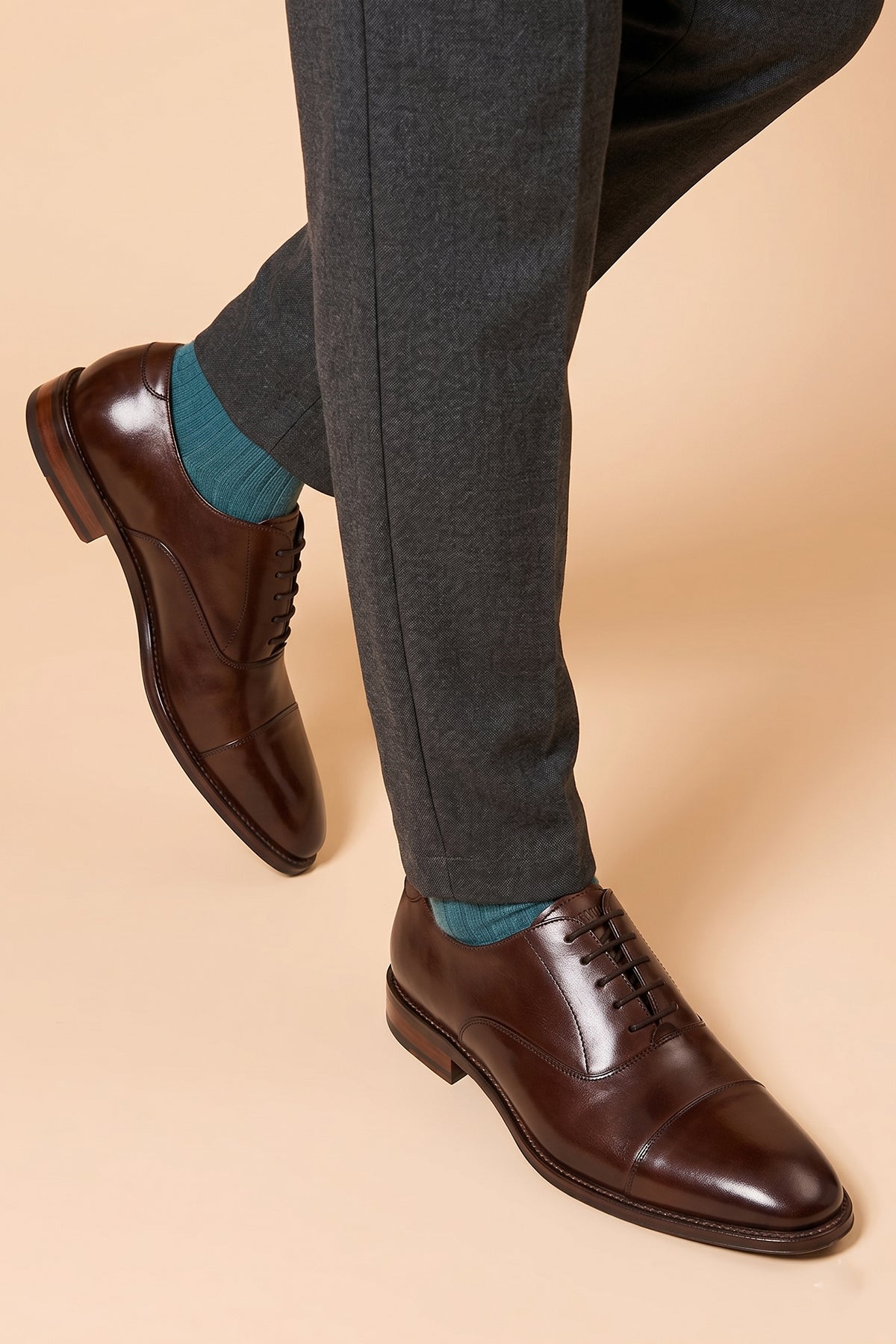 Model wearing Jarred Brown mens premium leather Oxford shoes featuring a distinctive toecap design and a polished brown finish.