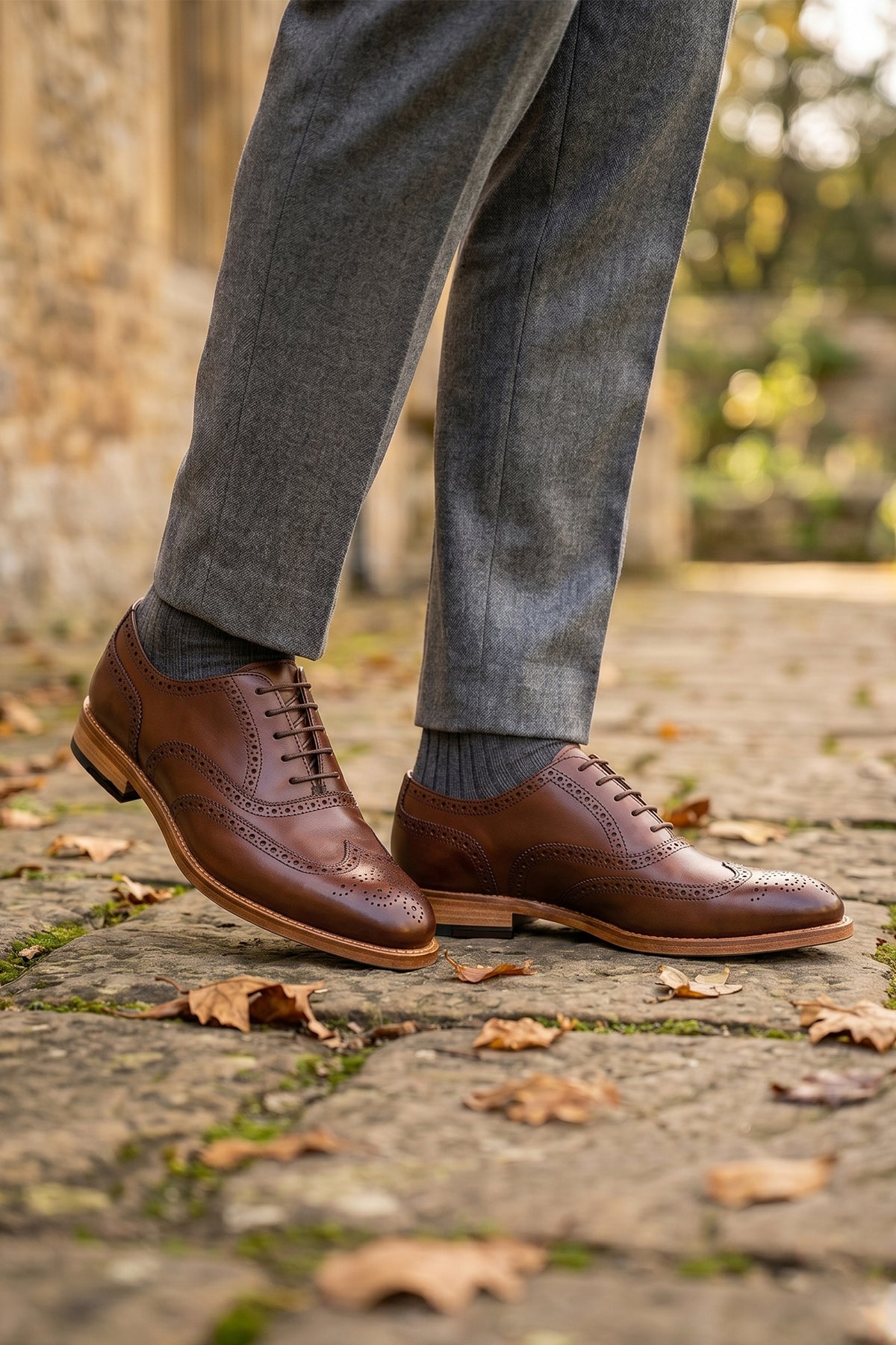 Model wearing Westminster brown leather Oxford brogue shoes for men, featuring a five-eyelet lace-up and classic toecap detail for a polished formal look.
