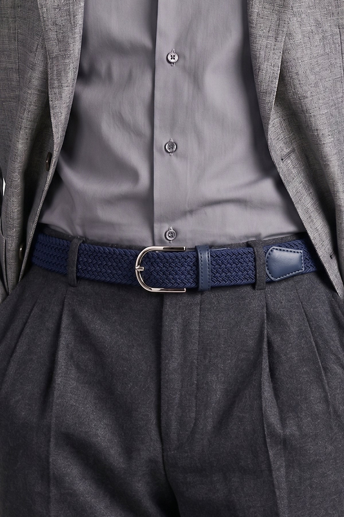 Man wearing the Aron Navy Belt with a grey shirt, jacket and charcoal trousers