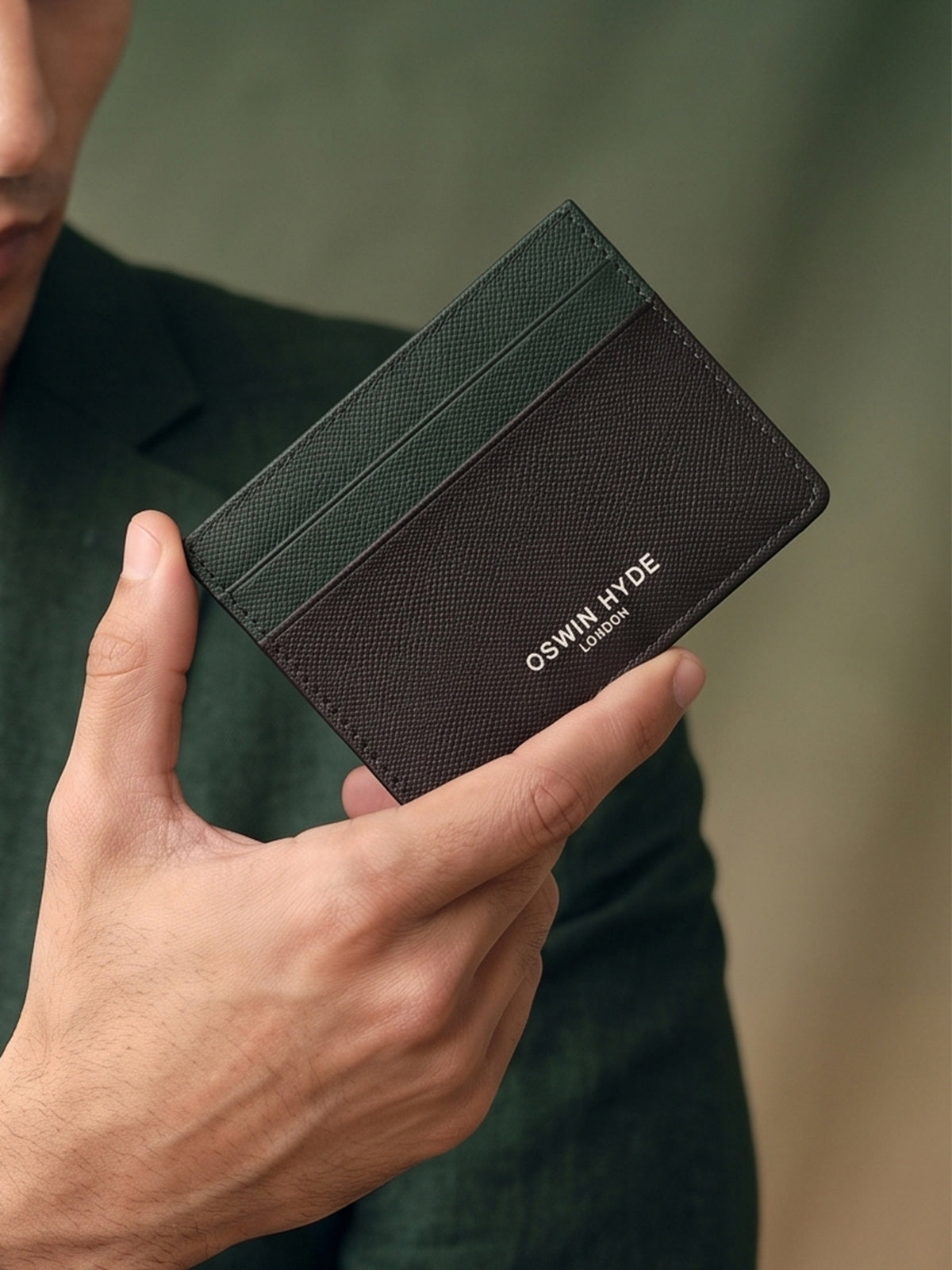 Man holding Holborn green saffiano leather card holder for men by Oswin Hyde – slim, luxury wallet with silver embossed logo and premium textured finish.