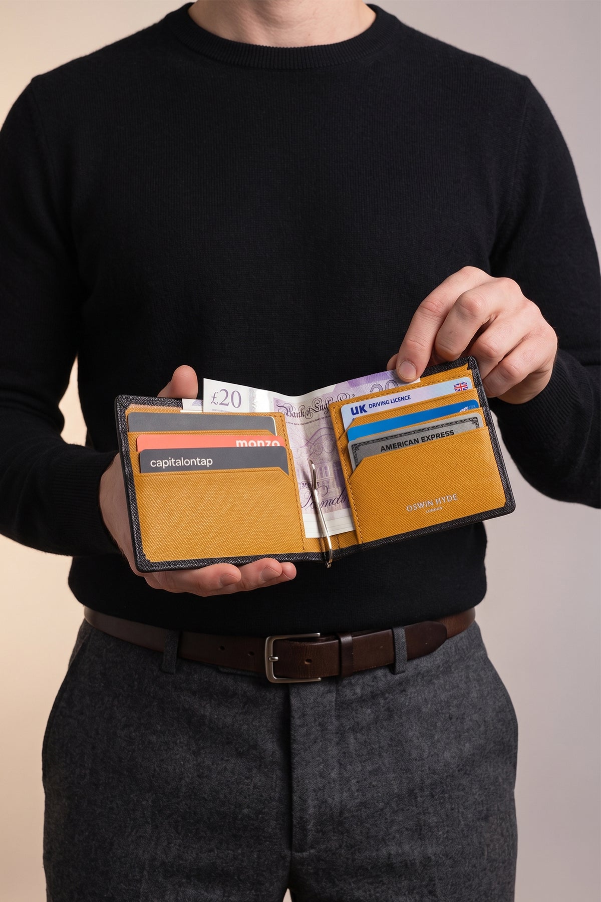Man holding Sloane tan saffiano leather money clip for men by Oswin Hyde – luxury slim design with silver embossing for stylish and practical everyday carry.