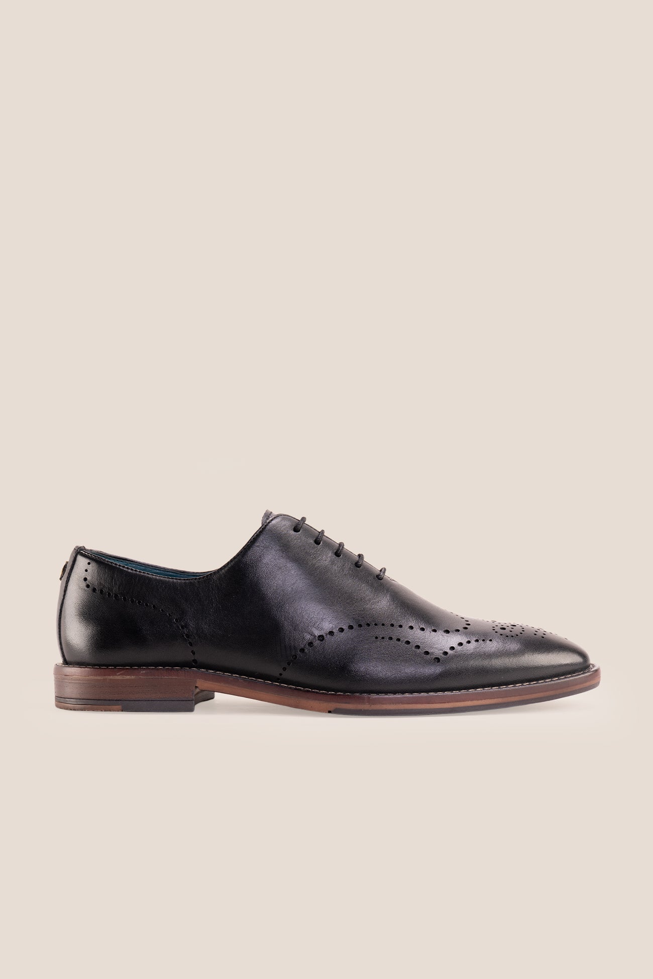 Oswin Hyde London premium black leather wingtip brogues with a toe medallion pattern, contrast welt stitching, and a cushioned teal interior.