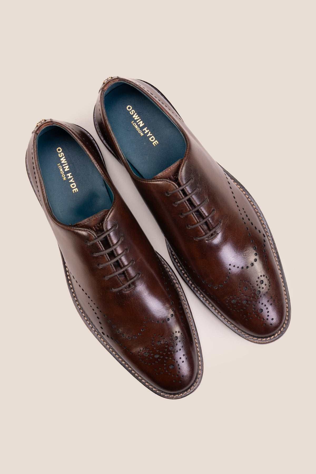 Oswin Hyde London premium Oakley brown leather wingtip brogues with a toe medallion pattern, contrast welt stitching, and a cushioned teal interior.