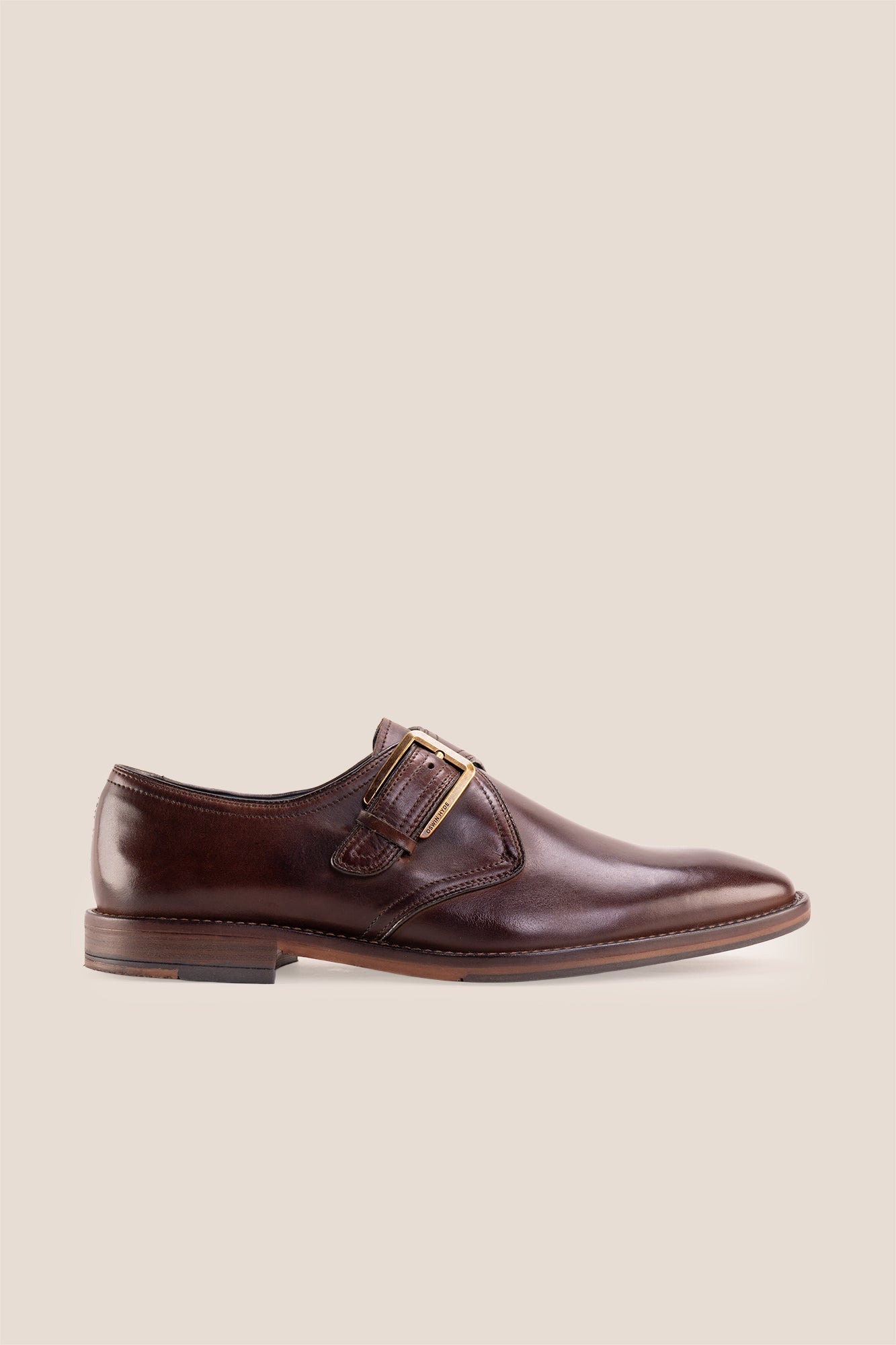 Premium men's brown leather single monk strap dress shoes by Oswin Hyde London featuring a plain toe, adjustable golden buckle, contrast sole stitching, and a cushioned teal interior.