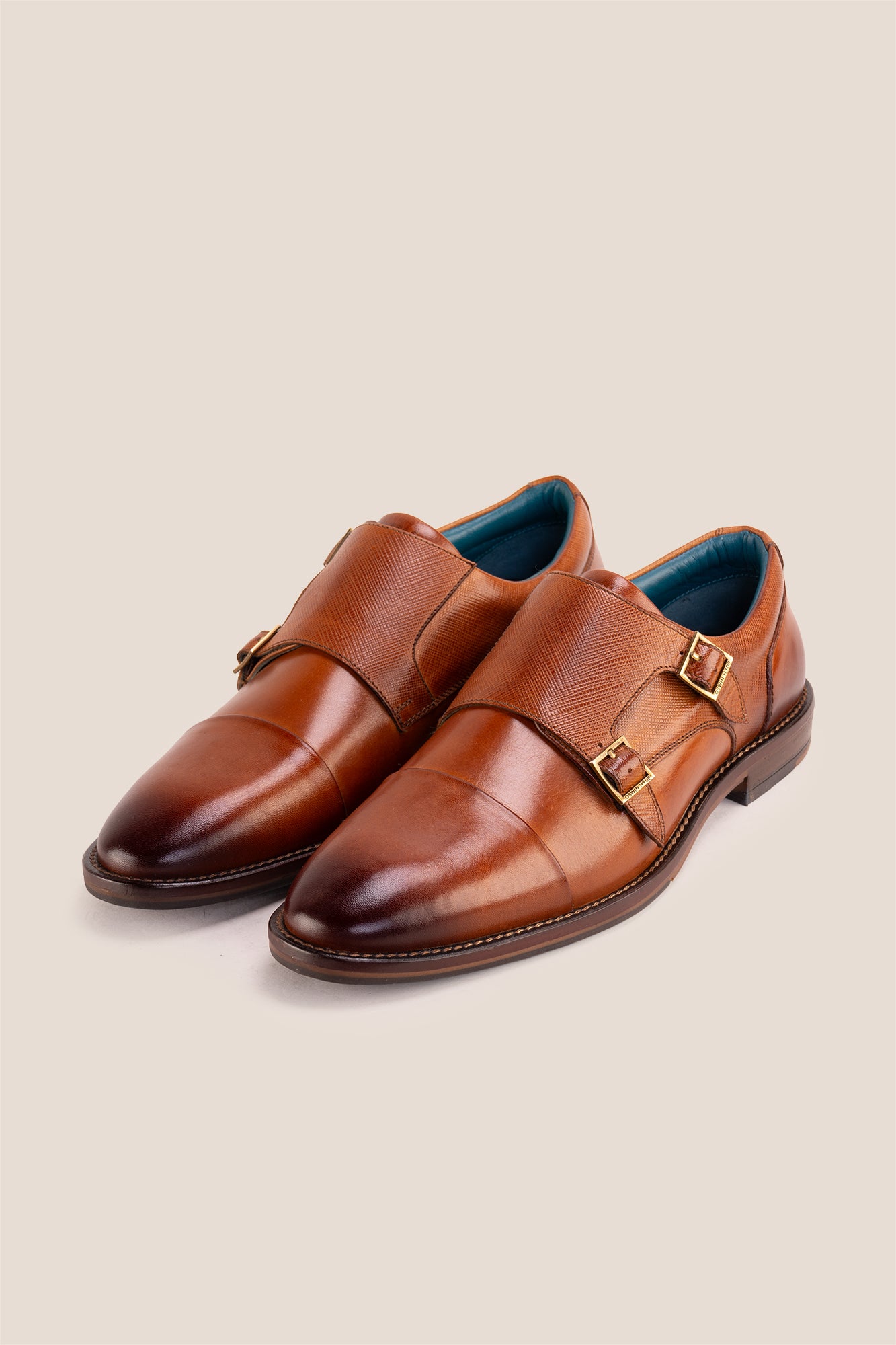 Kayden Tan leather monk strap shoes by OSWIN HYDE for men. Toe cap designed with saffiano print, cushioned insole and padded topline.