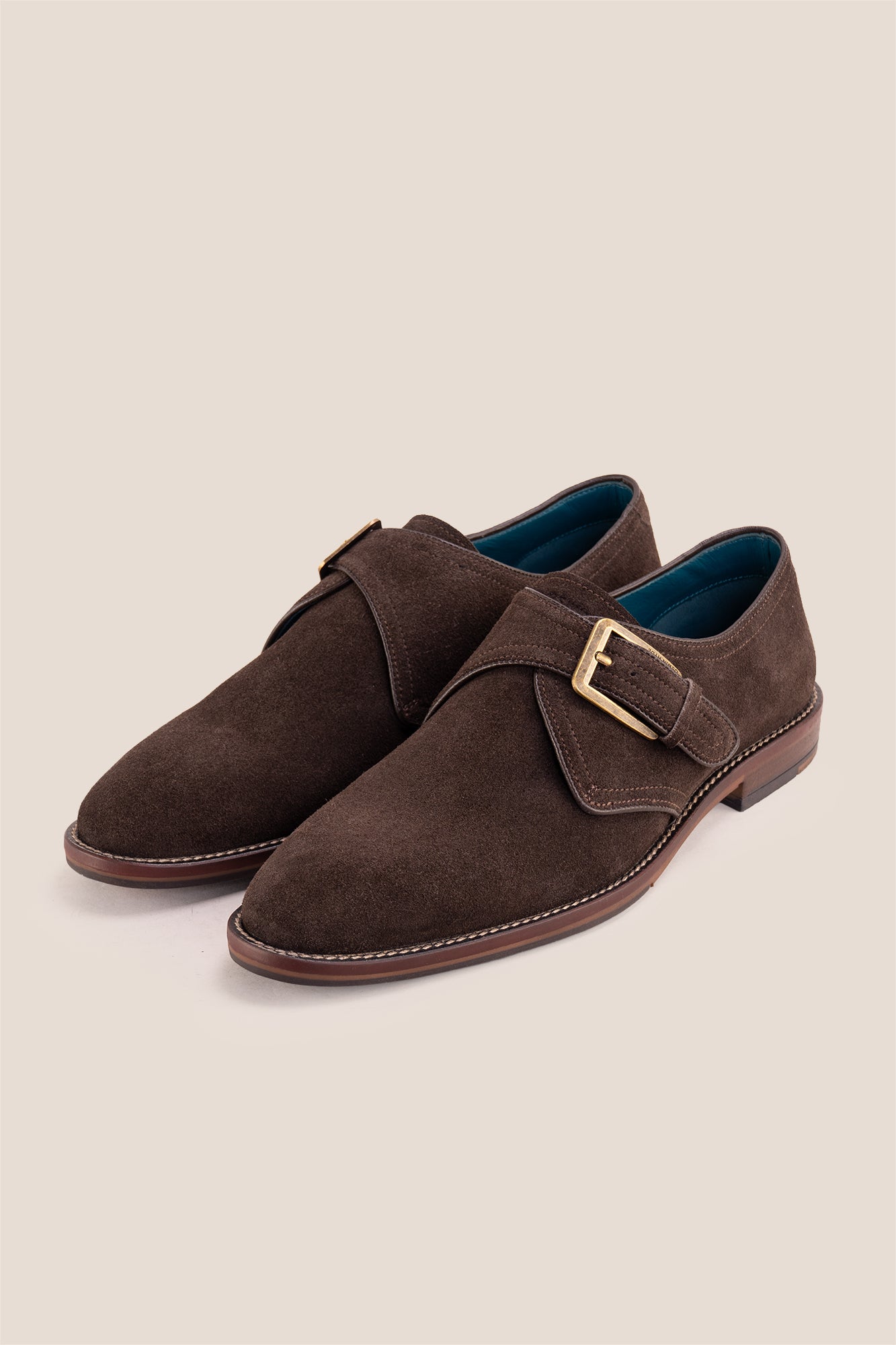 Premium men's brown suede single monk strap shoes by Oswin Hyde London, featuring a plain toe, adjustable silver buckle, contrast sole stitching, and a cushioned teal interior.