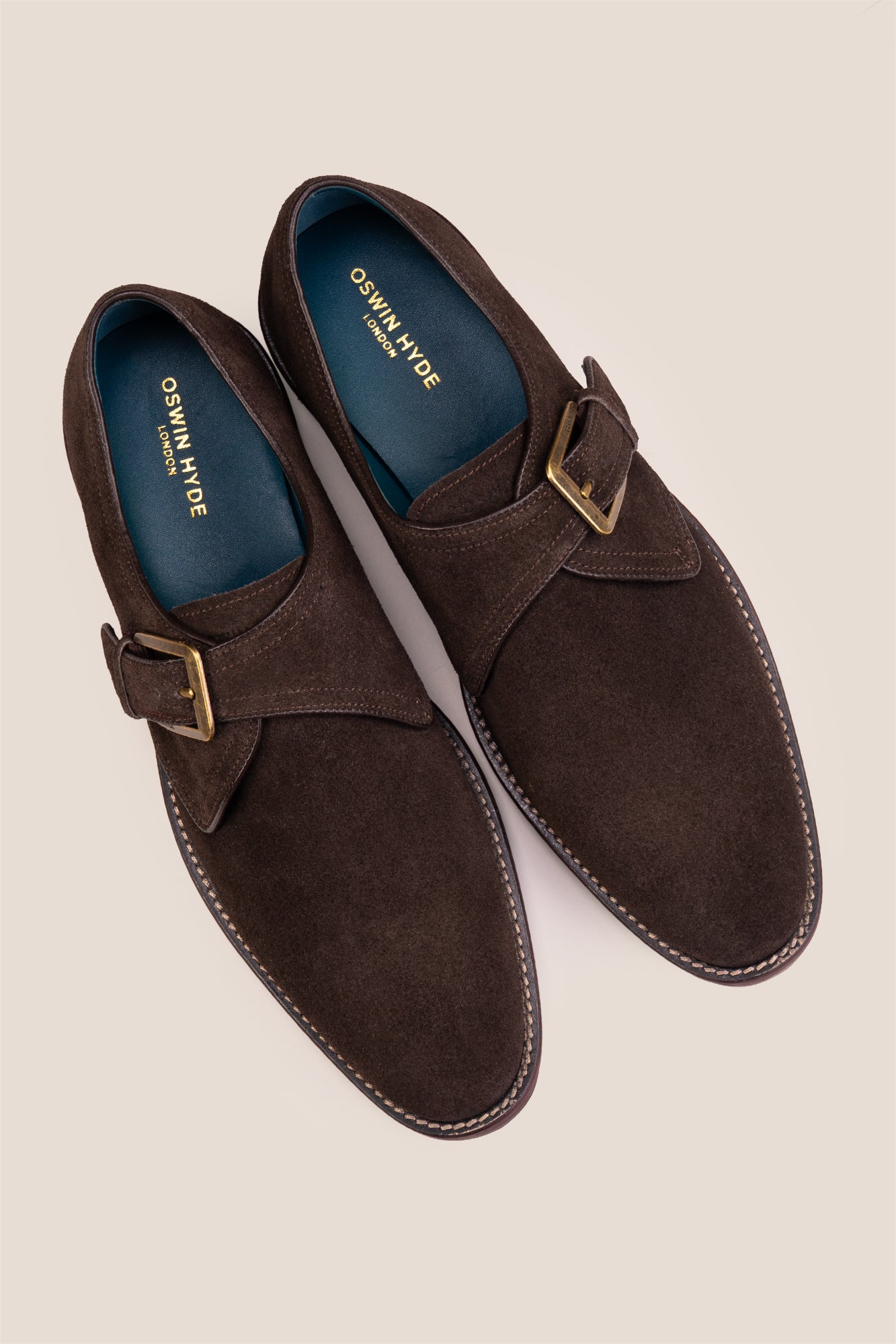 Premium men's brown suede single monk strap shoes by Oswin Hyde London, featuring a plain toe, adjustable silver buckle, contrast sole stitching, and a cushioned teal interior.