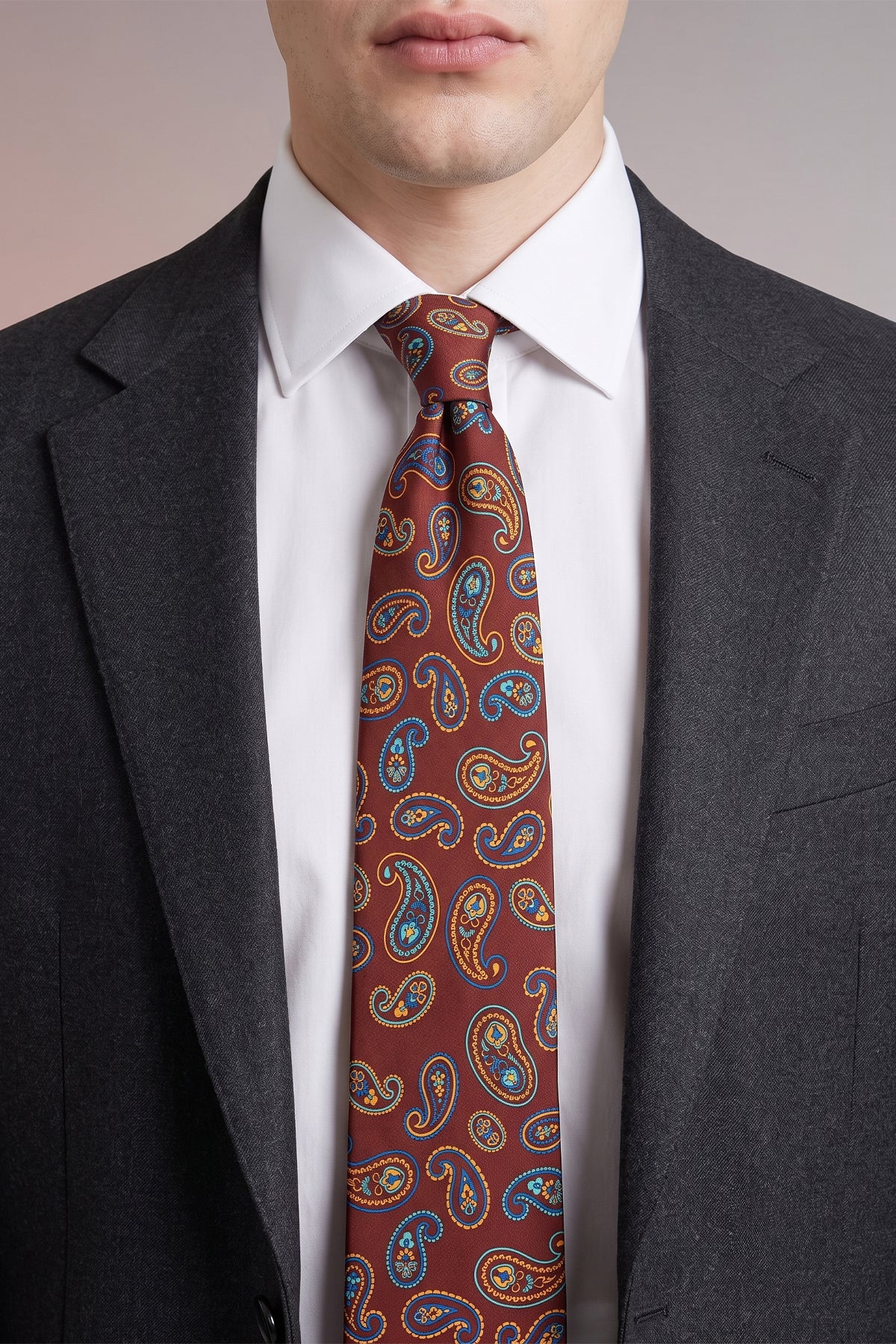 Man wearing Bordo Paisley Silk Tie with paisley design, offering luxury and sophistication for special occasions.
