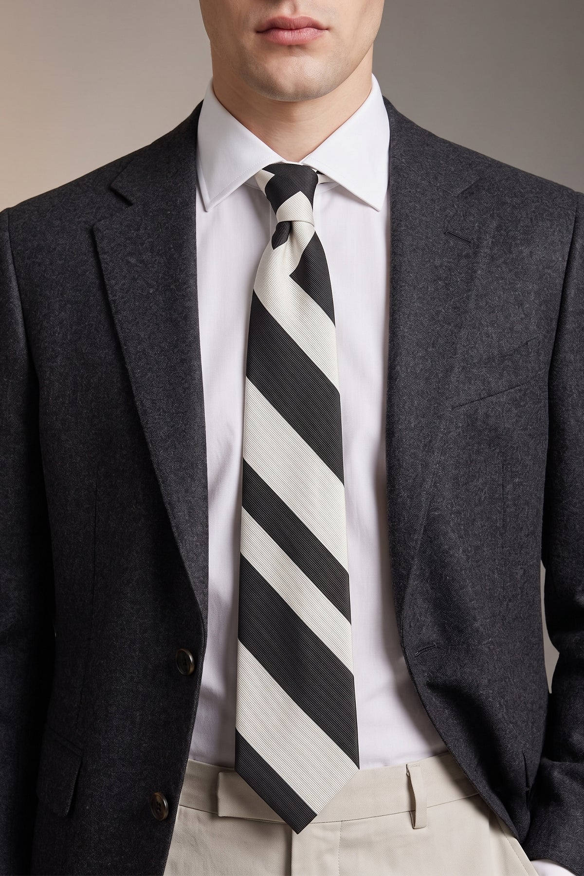 Man wearing Black White Stripes tie for men, designed to add a bold and elegant touch to your wardrobe. Featuring striking black and white stripes made from high quality materials.