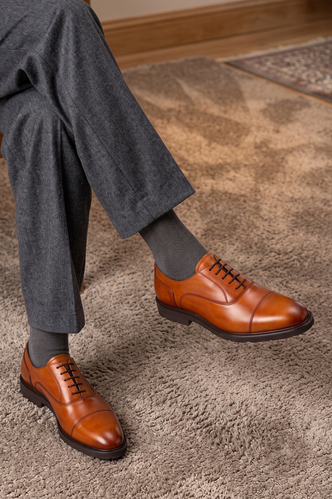 Model wearing Oswin Hyde Flint Tan, classic tan leather Oxford shoes with lace-up design, premium craftsmanship, breathable lining, and durable sole