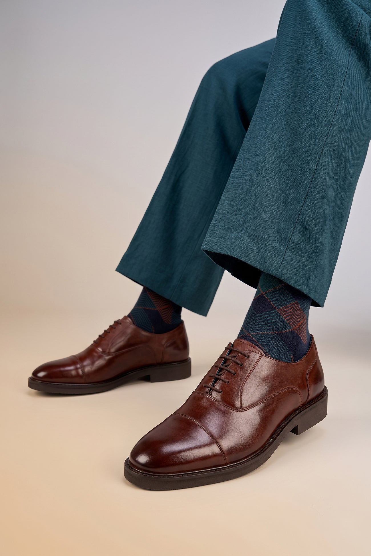 Model wearing Oswin Hyde Flint Brown, classic brown leather Oxford shoes with lace-up design, premium craftsmanship, breathable lining, and durable sole
