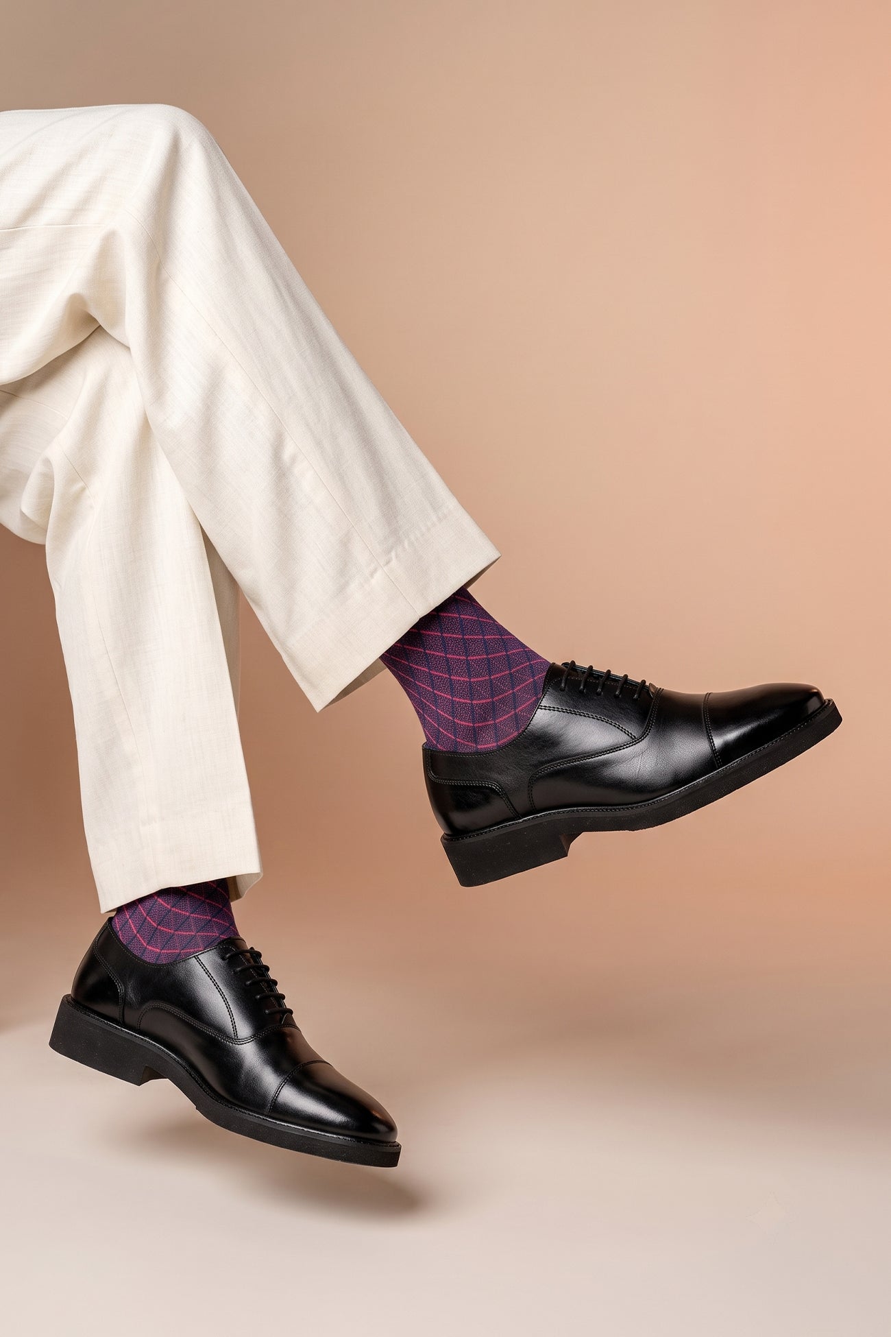 Model wearing Flint Black Oxford lace-up men’s leather shoes with a sleek silhouette and polished finish, ideal for formal and professional wear.
