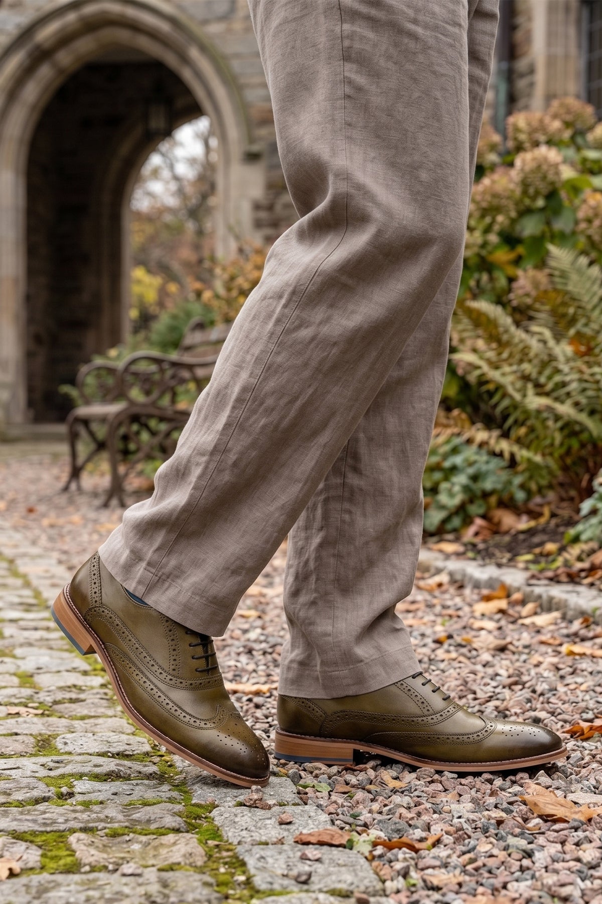 Man wearing Winston men’s Oxford brogue shoes in green leather with wingtip detail, perforated accents, and a classic lace-up silhouette—crafted for formal distinction.