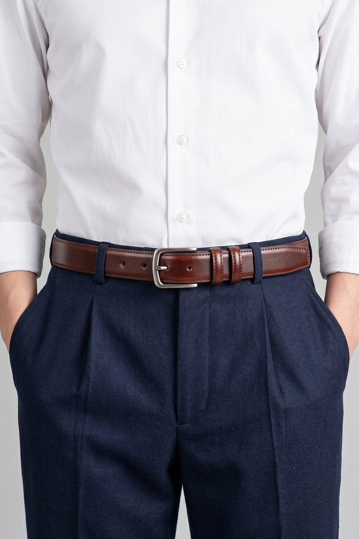 Man wearing Oswin Hyde Neil Brown men’s belt in luxury dark brown - Full-grain leather dress belt with polished nickel buckle, designed for formal suits, business attire and smart casual wear