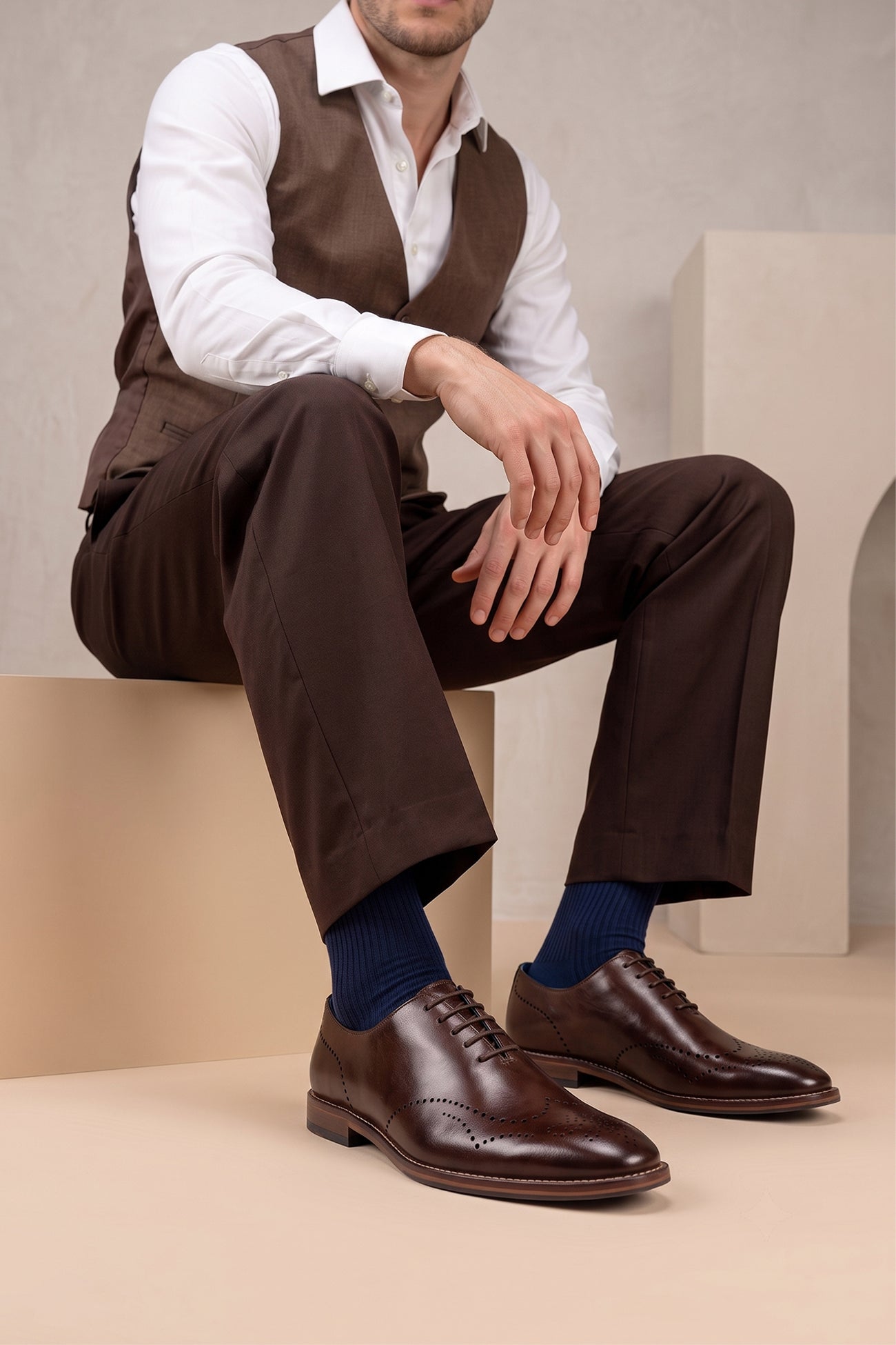 Man wearing Oswin Hyde London premium Oakley brown leather wingtip brogues with a toe medallion pattern, contrast welt stitching, and a cushioned teal interior.