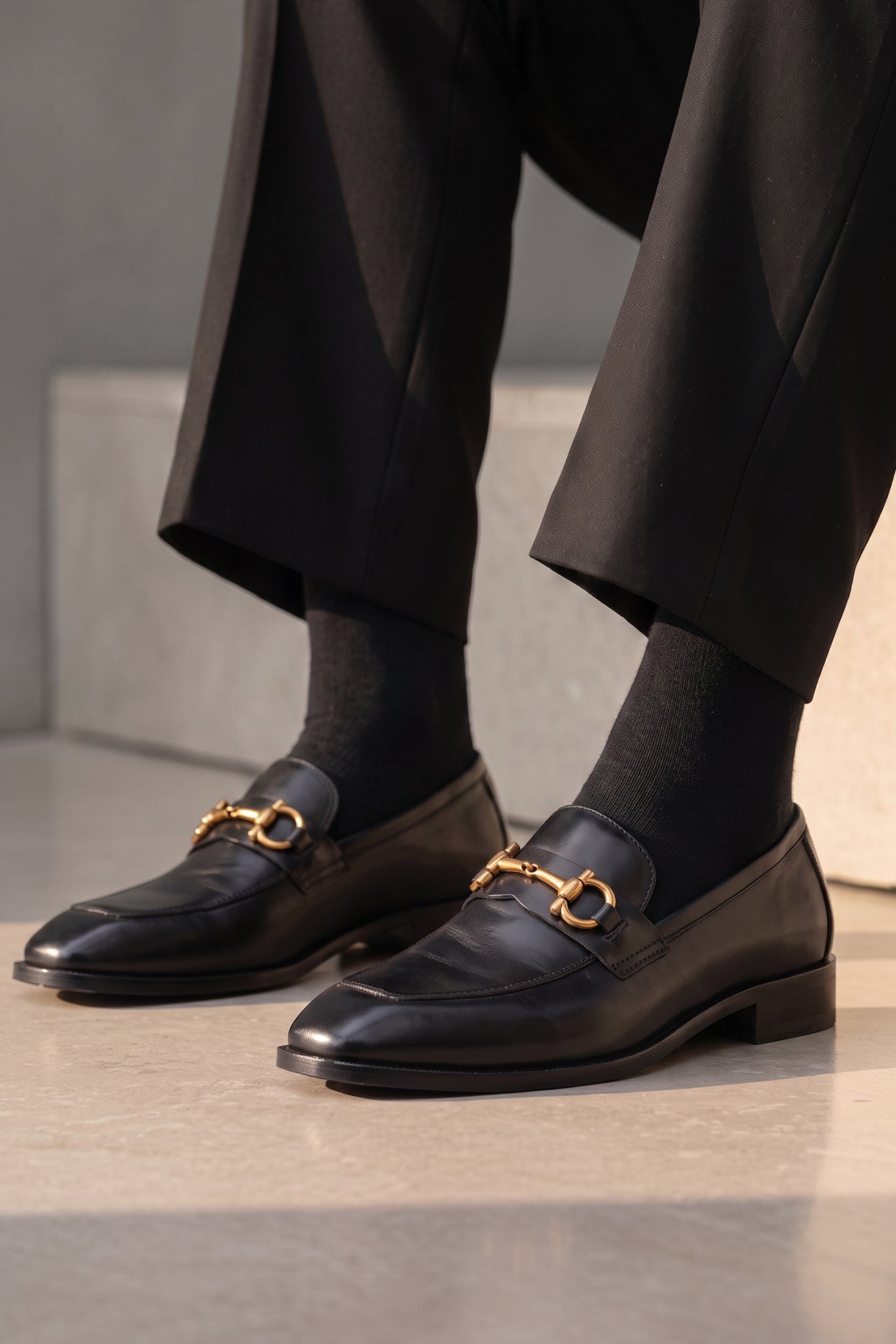 The men's smart black loafers feature an iconic gold horsebit detail and premium full-grain leather, perfect for formal occasions, suit tailoring, and smart-casual styling.