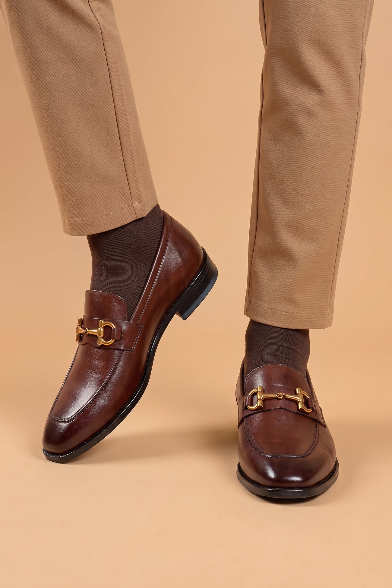 The men's smart brown loafers feature an iconic gold horsebit detail and rich dark brown full-grain leather, perfect for dressing up suits, business settings, and elevating casual wear.