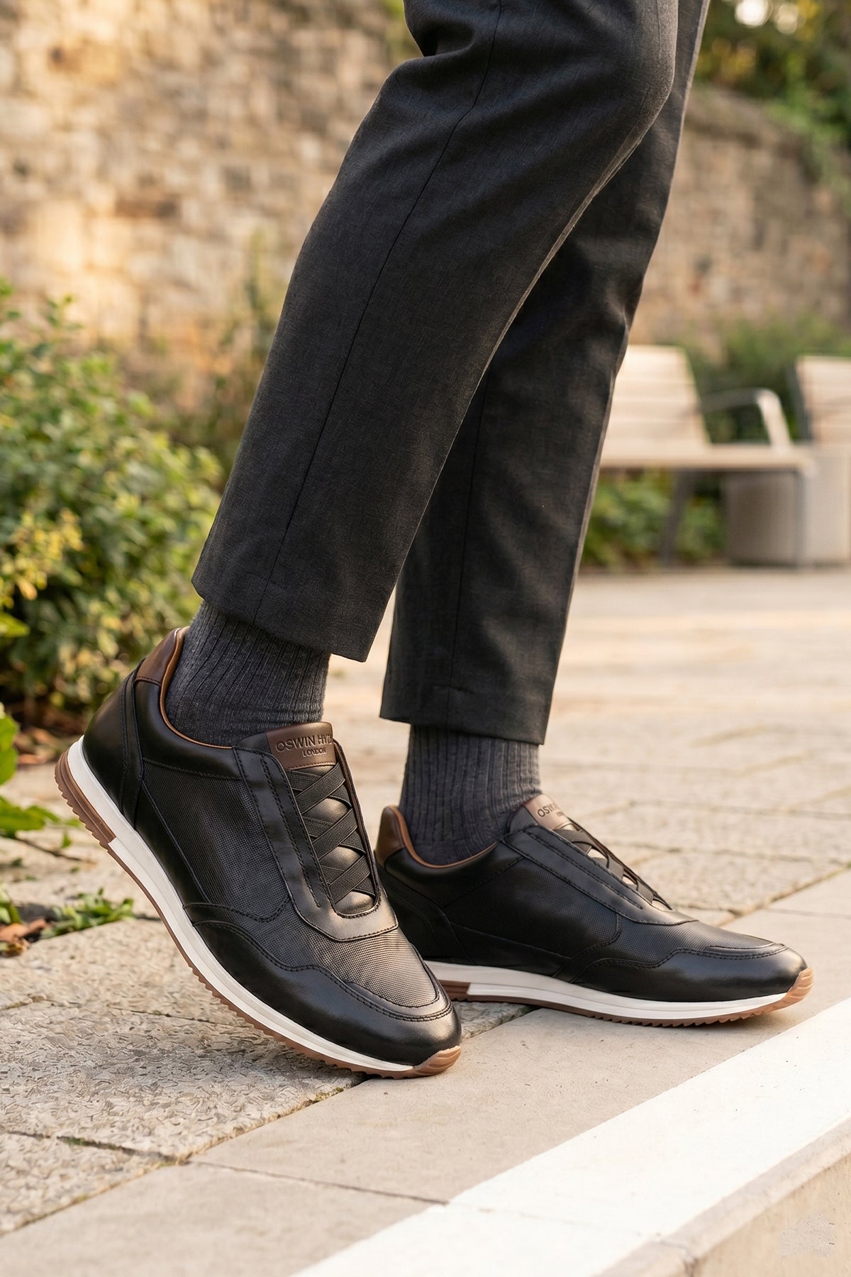 Model wearing Colt black men's leather sneakers with elastic detailing for a secure, comfortable fit and sleek, modern style.